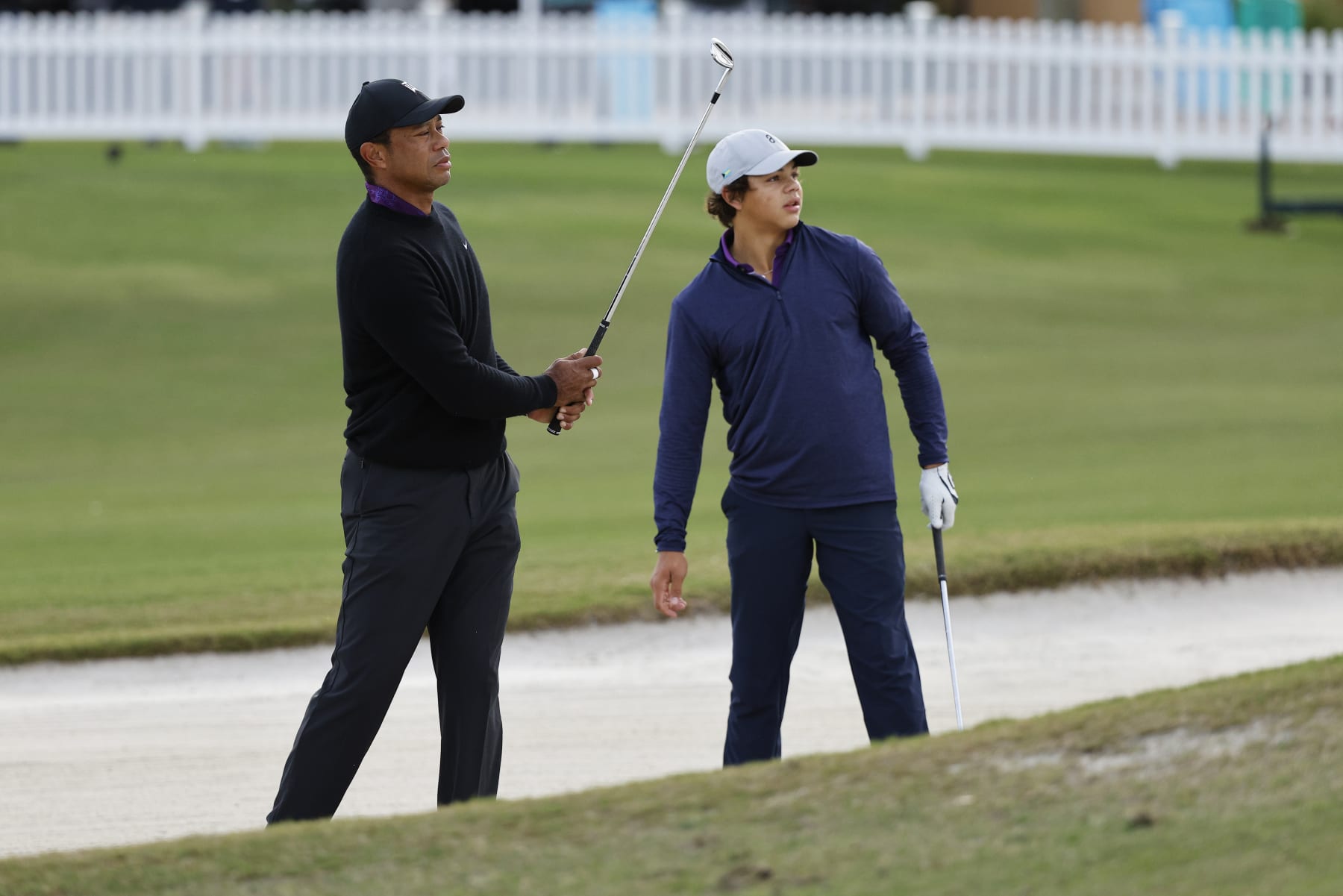 ORLANDO, FLORIDA - DECEMBER 15: Tiger Woods of the United States warms up in a bunker as son Charlie Woods looks on during the pro-am prior to the PNC Championship at The Ritz-Carlton Golf Club on December 15, 2023 in Orlando, Florida. (Photo by Mike Mulholland/Getty Images)