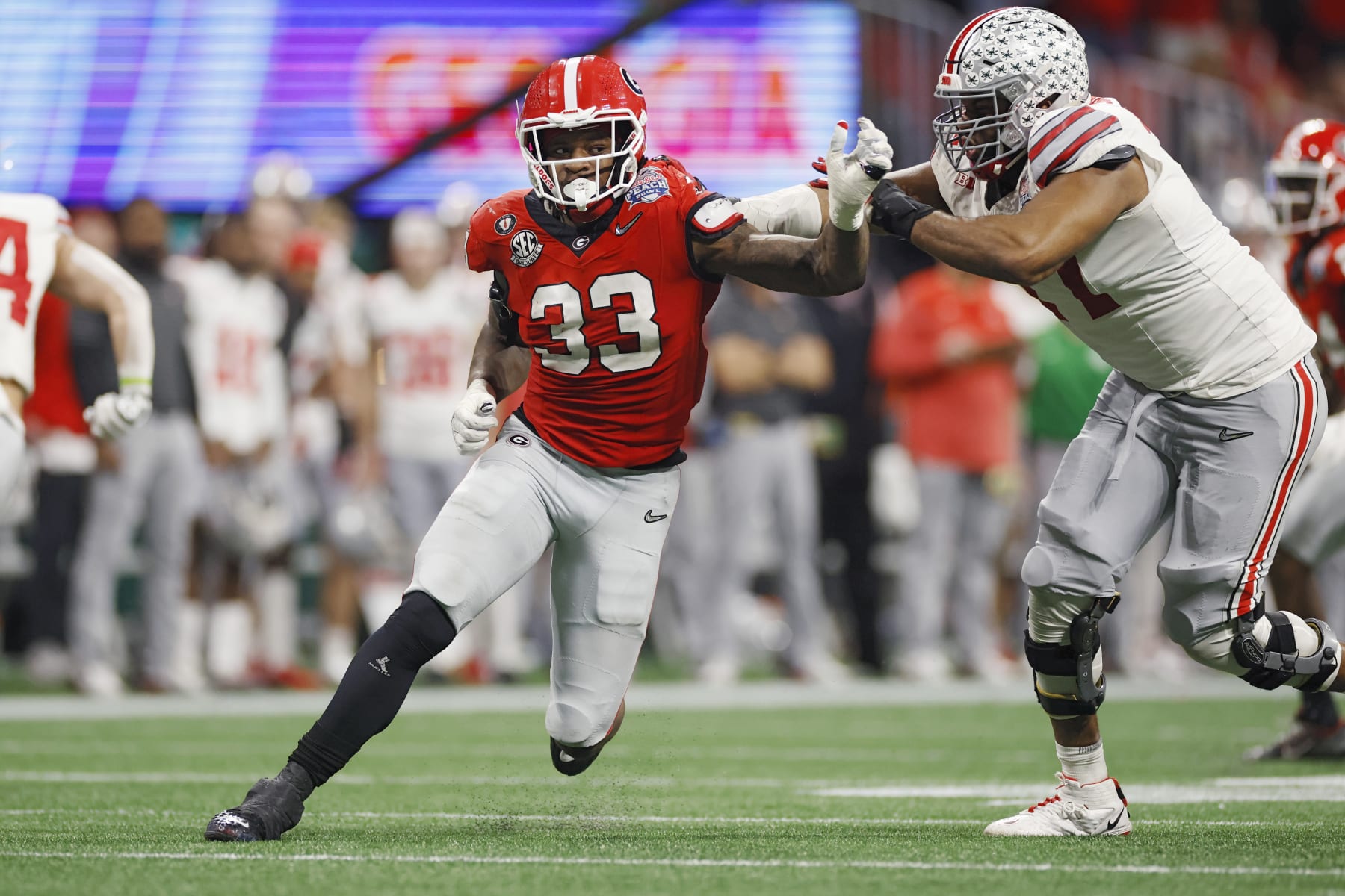 ATLANTA, GA - DECEMBER 31: Georgia Bulldogs linebacker Robert Beal Jr. (33) rushes on defense during the Chick-fil-A Peach Bowl semifinal game against the Ohio State Buckeyes on December 31, 2022 at Mercedes-Benz Stadium in Atlanta, Georgia. (Photo by Joe Robbins/Icon Sportswire via Getty Images)