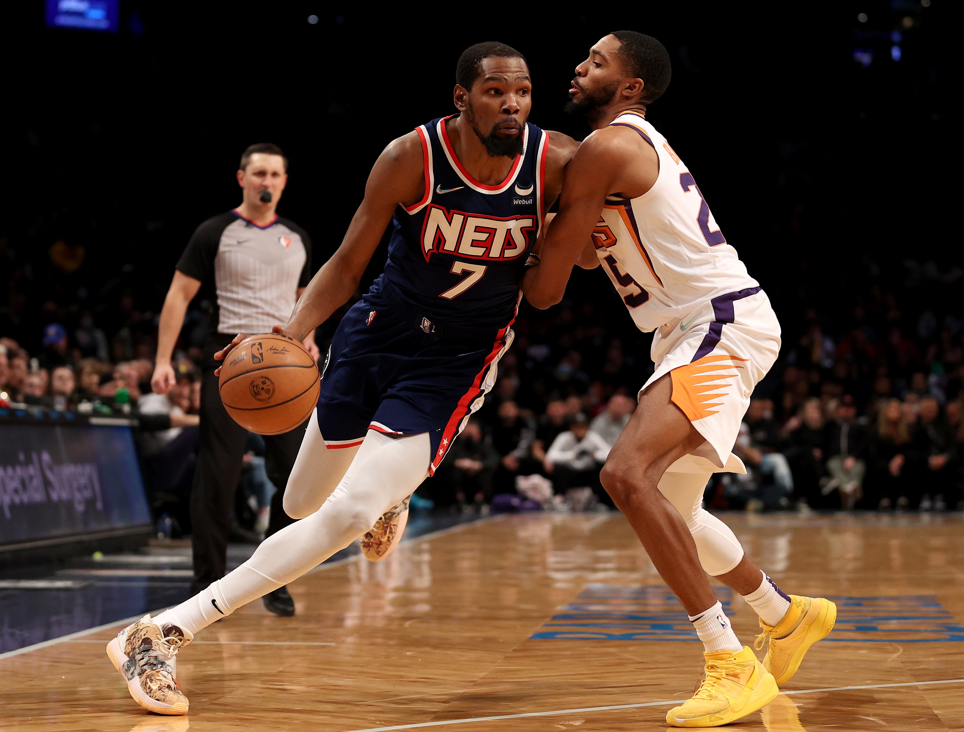 NEW YORK, NEW YORK - NOVEMBER 27:  Kevin Durant #7 of the Brooklyn Nets heads for the net as Mikal Bridges #25 of the Phoenix Suns defends at Barclays Center on November 27, 2021 in New York City. The Phoenix Suns defeated the Brooklyn Nets 113-107. NOTE TO USER: User expressly acknowledges and agrees that, by downloading and or using this photograph, User is consenting to the terms and conditions of the Getty Images License Agreement. (Photo by Elsa/Getty Images)