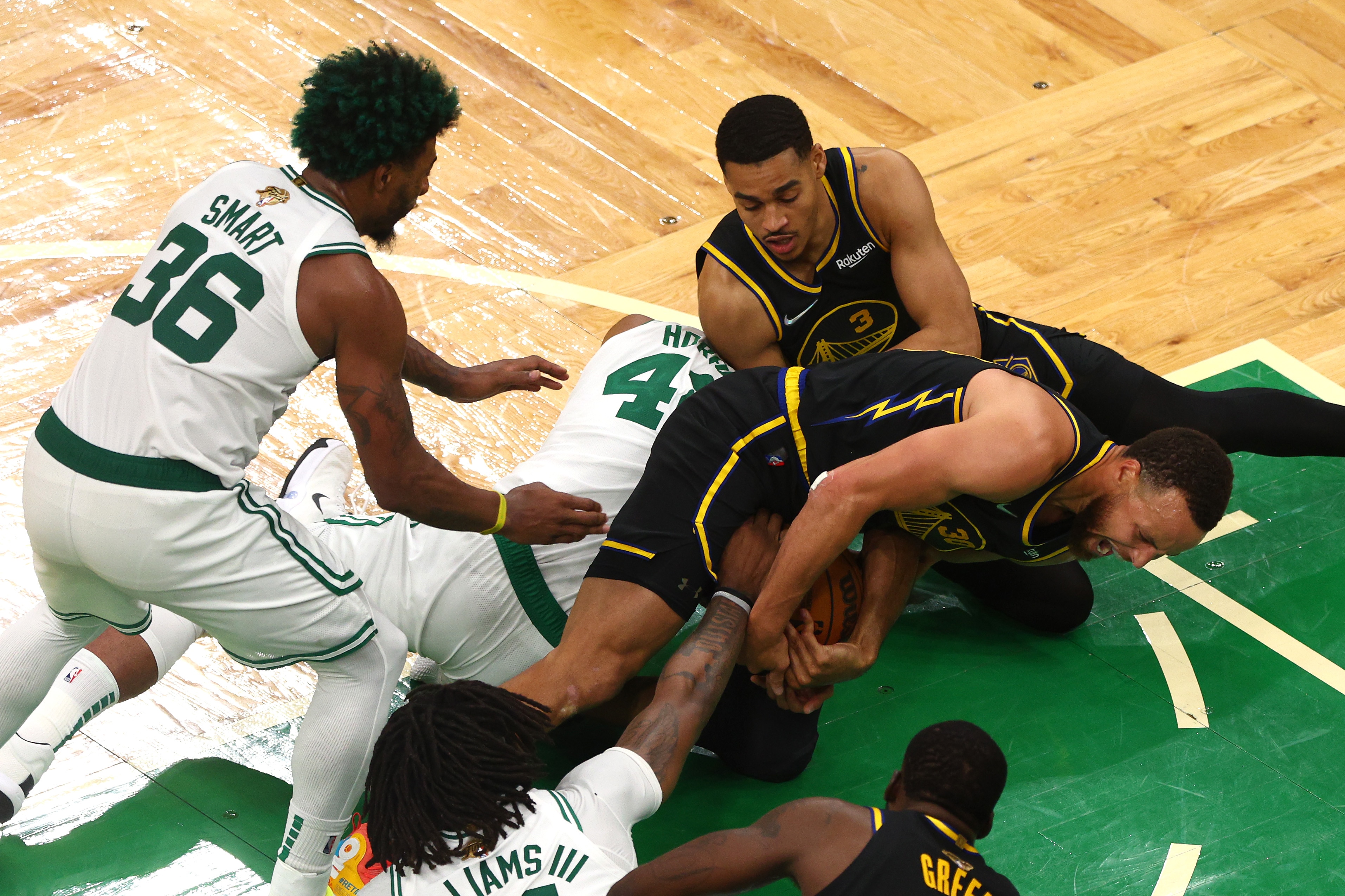 BOSTON, MASSACHUSETTS - JUNE 08: Stephen Curry #30 and Jordan Poole #3 of the Golden State Warriors compete for a loose ball against Al Horford #42 of the Boston Celtics in the fourth quarter during Game Three of the 2022 NBA Finals at TD Garden on June 08, 2022 in Boston, Massachusetts. The Boston Celtics won 116-100. NOTE TO USER: User expressly acknowledges and agrees that, by downloading and/or using this photograph, User is consenting to the terms and conditions of the Getty Images License Agreement. (Photo by Elsa/Getty Images)