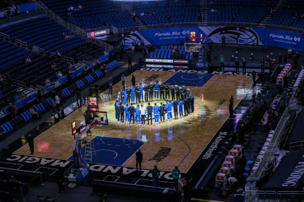 ORLANDO, FL - APRIL 12: Orlando Magic and San Antonio Spurs players stand in a circle during the United States national anthem at Amway Center on April 12, 2021 in Orlando, Florida. NOTE TO USER: User expressly acknowledges and agrees that, by downloading and or using this photograph, User is consenting to the terms and conditions of the Getty Images License Agreement. (Photo by Alex Menendez/Getty Images)