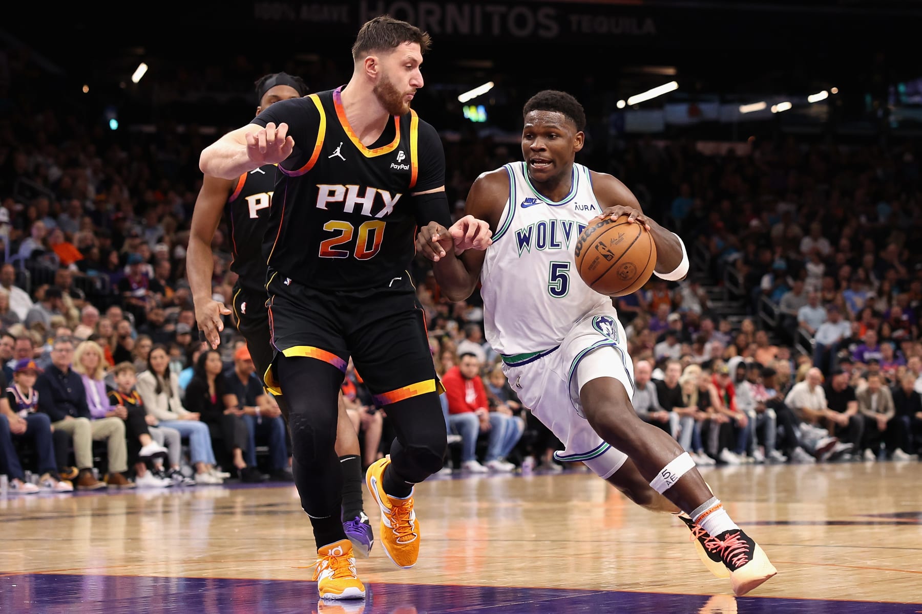 PHOENIX, ARIZONA - NOVEMBER 15: Anthony Edwards #5 of the Minnesota Timberwolves drives the ball past Jusuf Nurkic #20 of the Phoenix Suns during the NBA game at Footprint Center on November 15, 2023 in Phoenix, Arizona. The Suns defeated the Timberwolves 133-115. NOTE TO USER: User expressly acknowledges and agrees that, by downloading and or using this photograph, User is consenting to the terms and conditions of the Getty Images License Agreement.  (Photo by Christian Petersen/Getty Images)