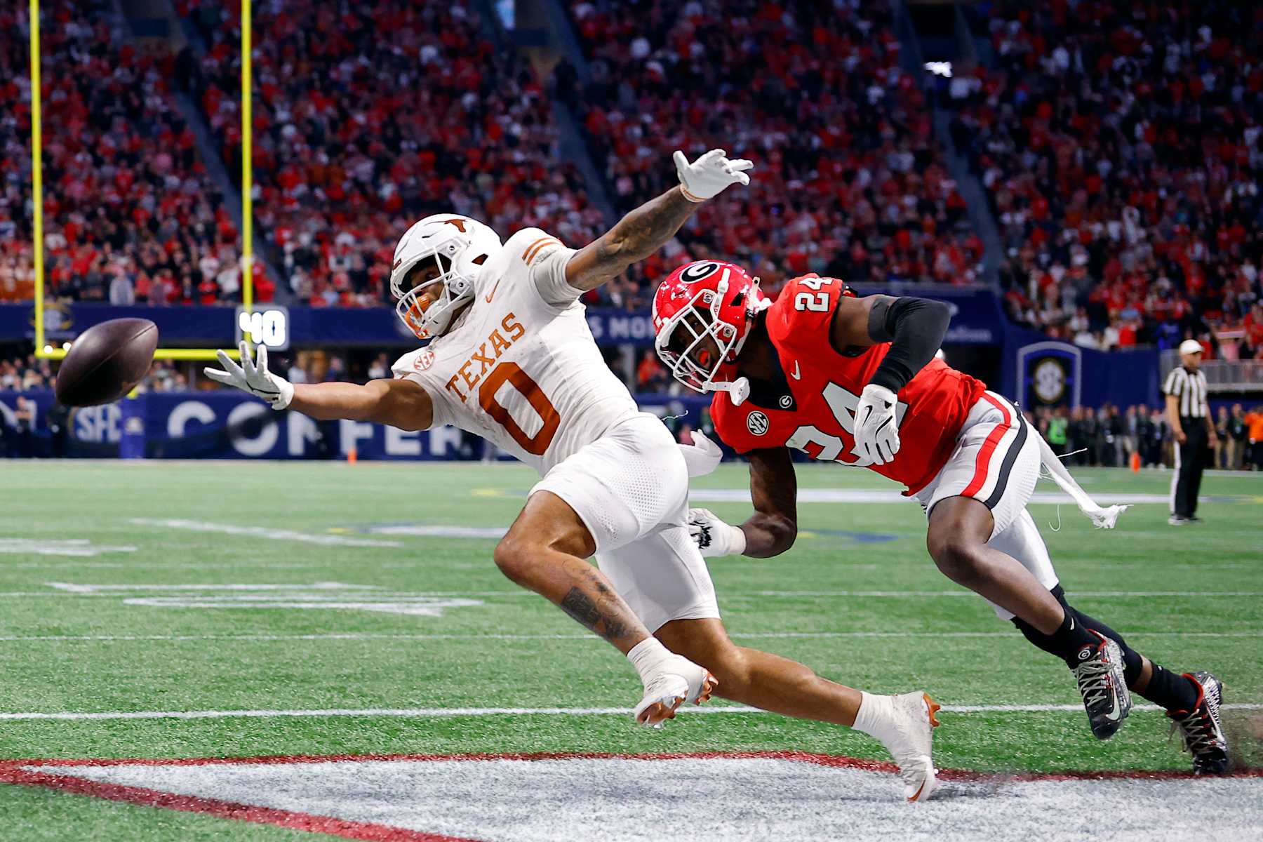 ATLANTA, GEORGIA - DECEMBER 07: DeAndre Moore Jr. #0 of the Texas Longhorns misses the catch under pressure from Malaki Starks #24 of the Georgia Bulldogs during overtime of the 2024 SEC Championship at Mercedes-Benz Stadium on December 07, 2024 in Atlanta, Georgia. (Photo by Todd Kirkland/Getty Images)