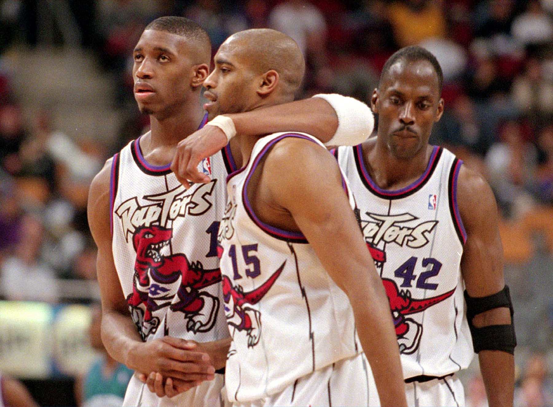 Tracy McGrady (L) consoles Vince Carter after Carter fouled out against the Charlotte Hornets April 27, 1999. Kevin Willis (r) looks on dejectedly. (BERNARD WEIL/TORONTO STAR) (Photo by Bernard Weil/Toronto Star via Getty Images)
