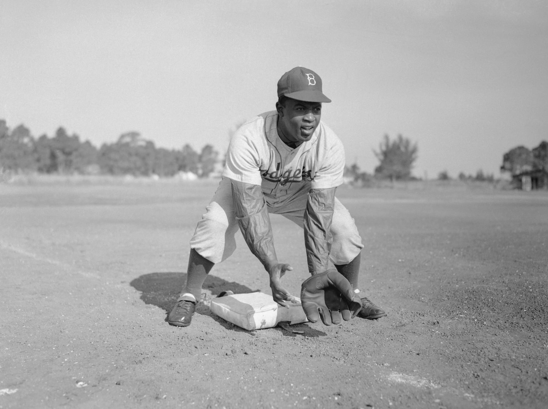 (Original Caption) 1949-Jackie Robinson during baseball practice. Here J. Robinson shown bending to catch a ground ball.