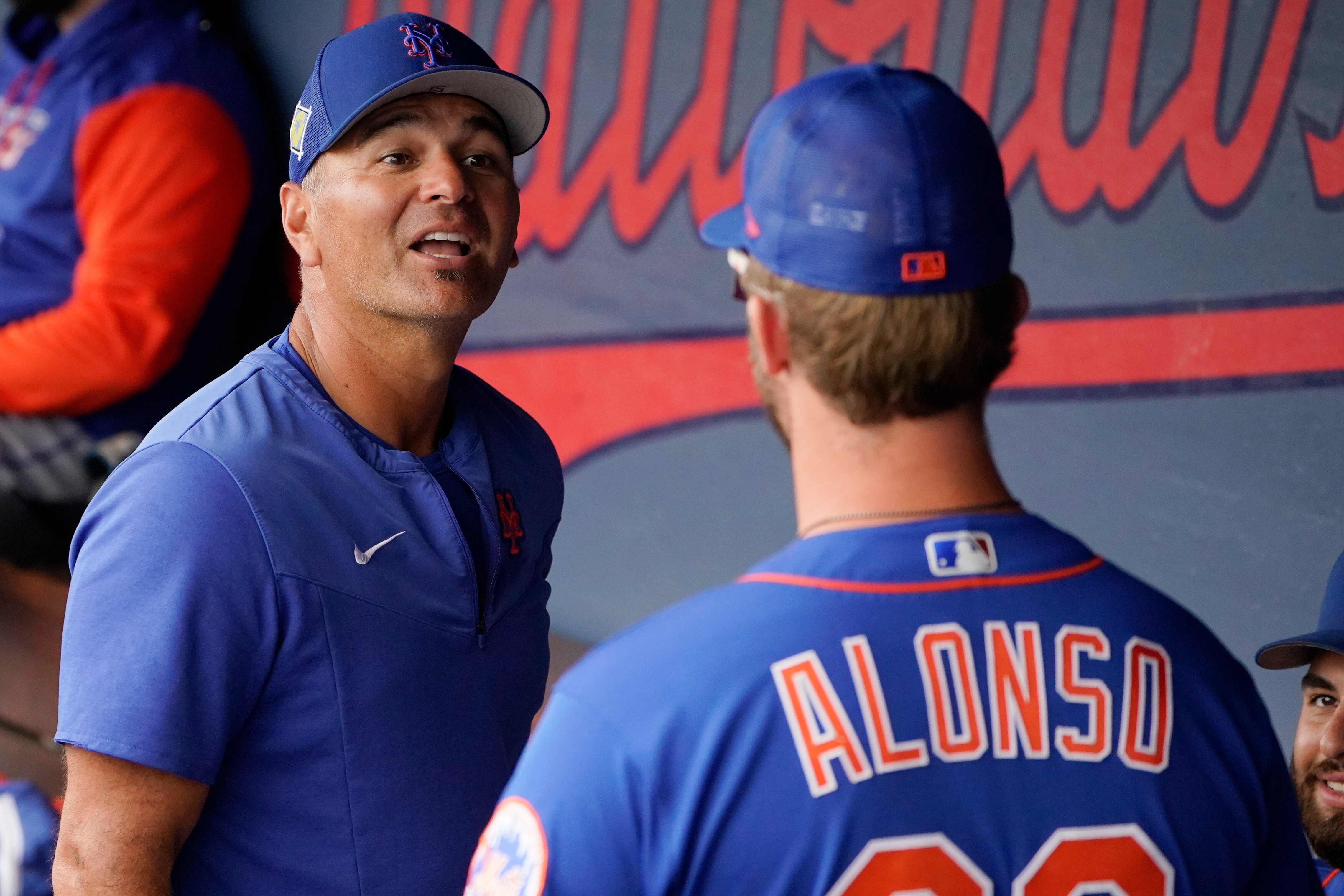 New York Mets hitting coach Eric Chavez, left, talks with Pete Alonso, right, in the dugout before a spring training baseball game against the Houston Astros, Monday, April 4, 2022, in West Palm Beach, Fla. (AP Photo/Sue Ogrocki)