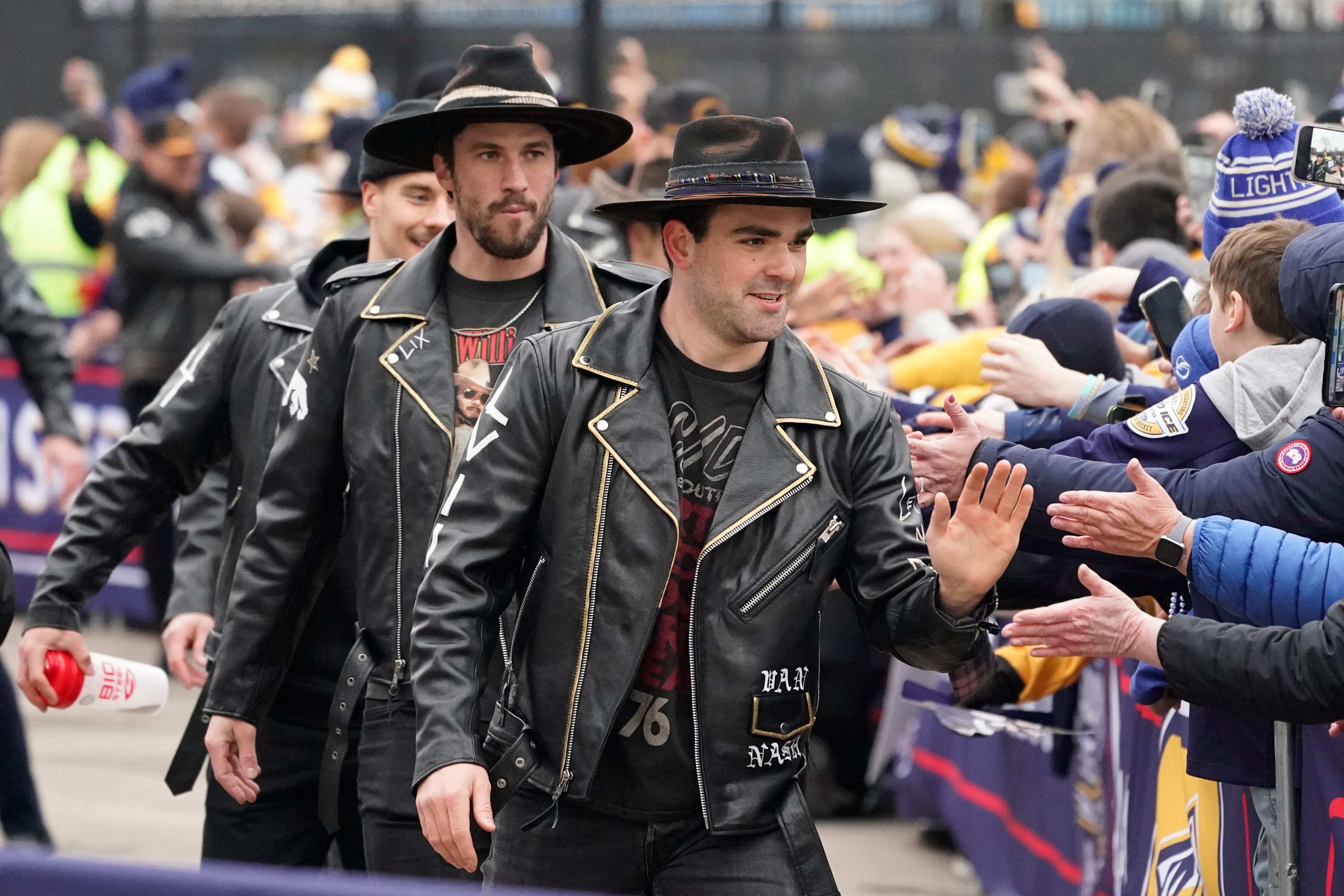 Nashville Predators defensemen Dante Fabbro, right, and Roman Josi greet fans as players arrive at Nissan Stadium before an NHL Stadium Series hockey game between the Predators and the Tampa Bay Lightning Saturday, Feb. 26, 2022, in Nashville, Tenn. (AP Photo/Mark Humphrey)
