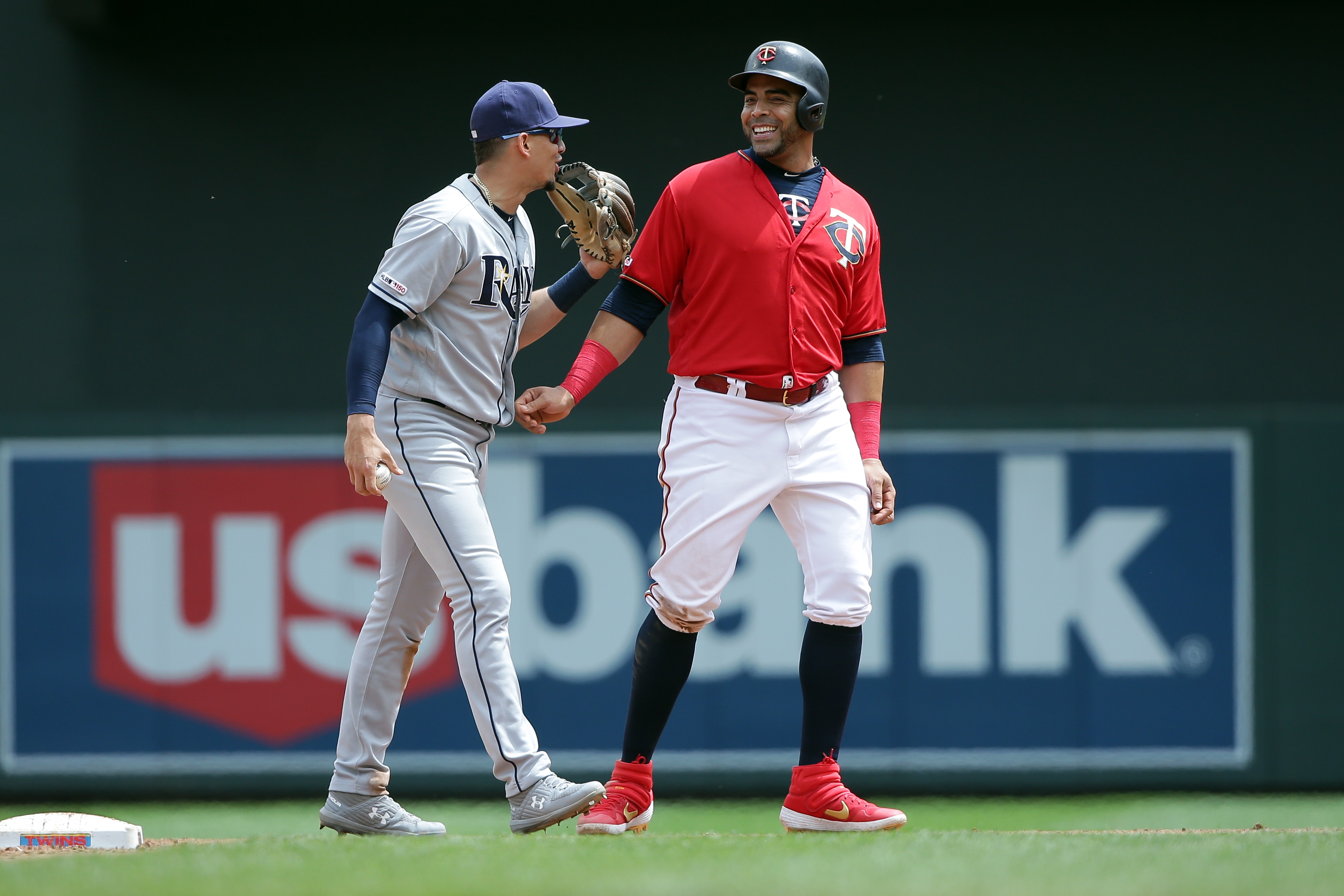 MINNEAPOLIS, MN - JUNE 27: Willy Adames #1 of the Tampa Bay Rays and Nelson Cruz #23 of the Minnesota Twins have a laugh during the game at Target Field on Thursday, June 27, 2019 in Minneapolis, Minnesota. (Photo by Brad Rempel/MLB via Getty Images)