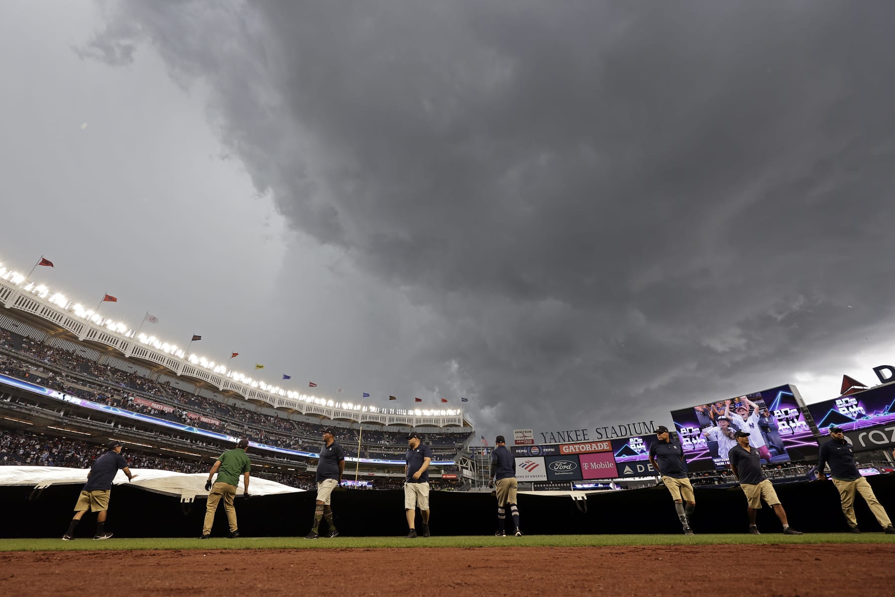 NEW YORK, NY - AUGUST 4: Members of the grounds crew put the tarp on the field as storm clouds cover Yankee Stadium during the eighth inning as Toronto Blue Jays takes on the New York Yankees on August 4, 2024 in New York City. (Photo by Adam Hunger/Getty Images)