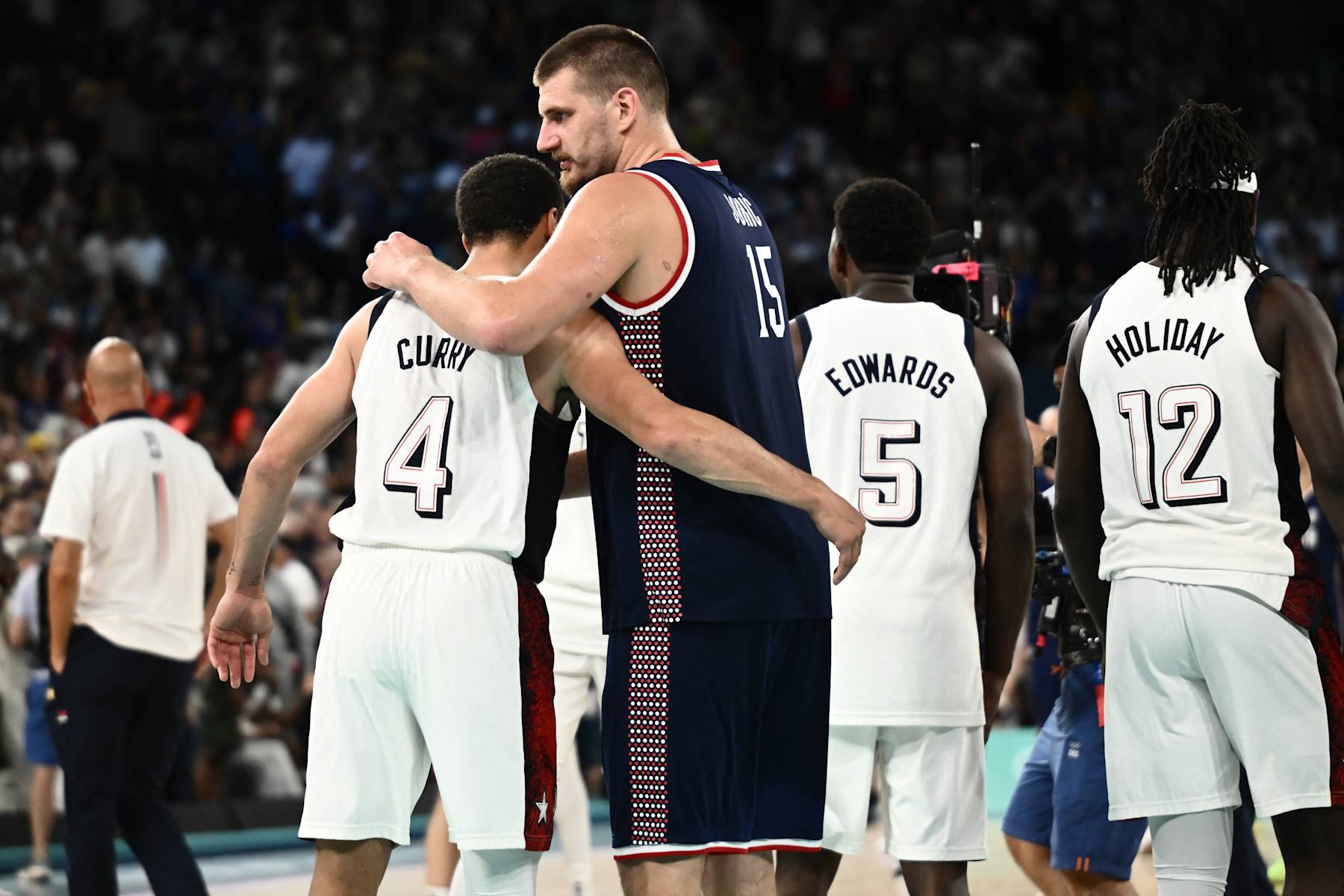 USA's #04 Stephen Curry (L) comforts Serbia's #15 Nikola Jokic at the end of the men's semifinal basketball match between USA and Serbia during the Paris 2024 Olympic Games at the Bercy  Arena in Paris on August 8, 2024. (Photo by Aris MESSINIS / AFP) (Photo by ARIS MESSINIS/AFP via Getty Images)
