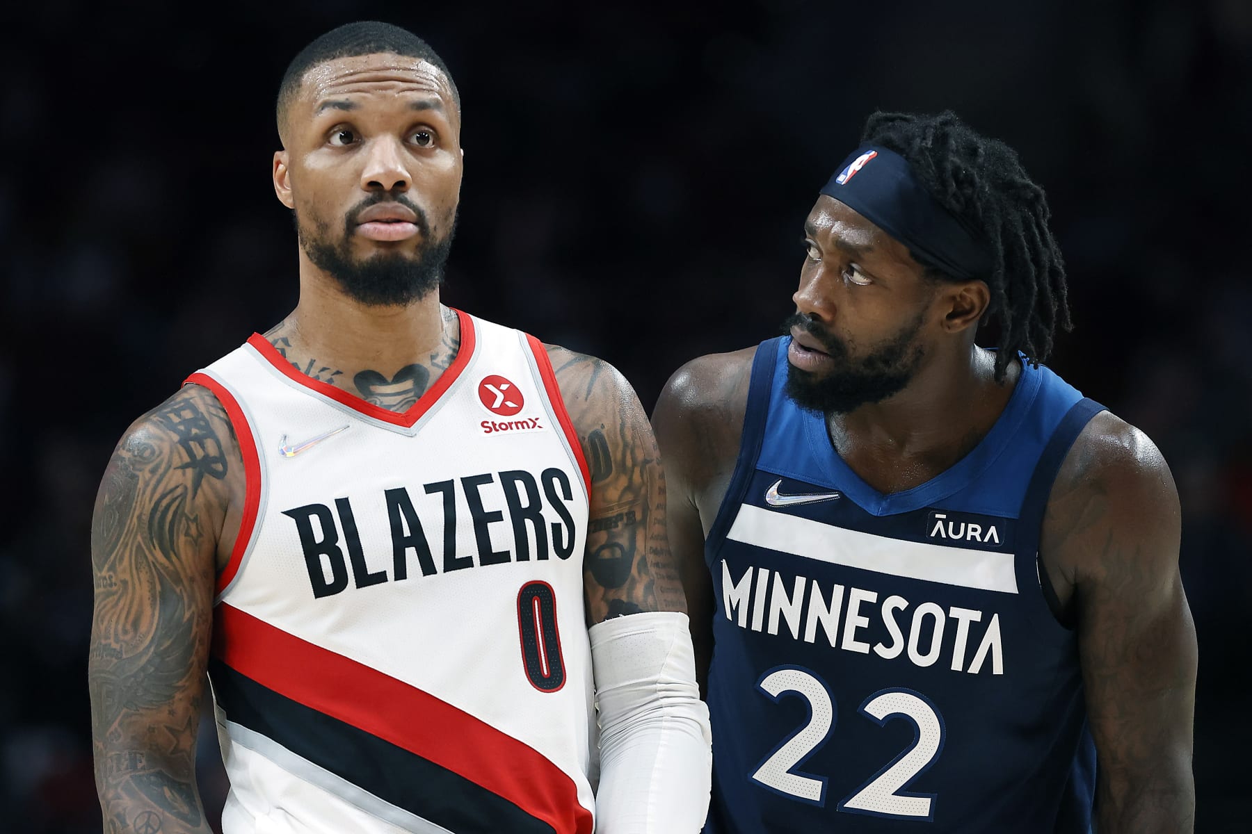 PORTLAND, OREGON - DECEMBER 12: Patrick Beverley # 22 of the Minnesota Timberwolves looks at Damian Lillard # 0 of the Portland Trail Blazers during the second half  at Moda Center on December 12, 2021 in Portland, Oregon. NOTE TO USER: User expressly acknowledges and agrees that, by downloading and or using this photograph, User is consenting to the terms and conditions of the Getty Images License Agreement. (Photo by Soobum Im/Getty Images)