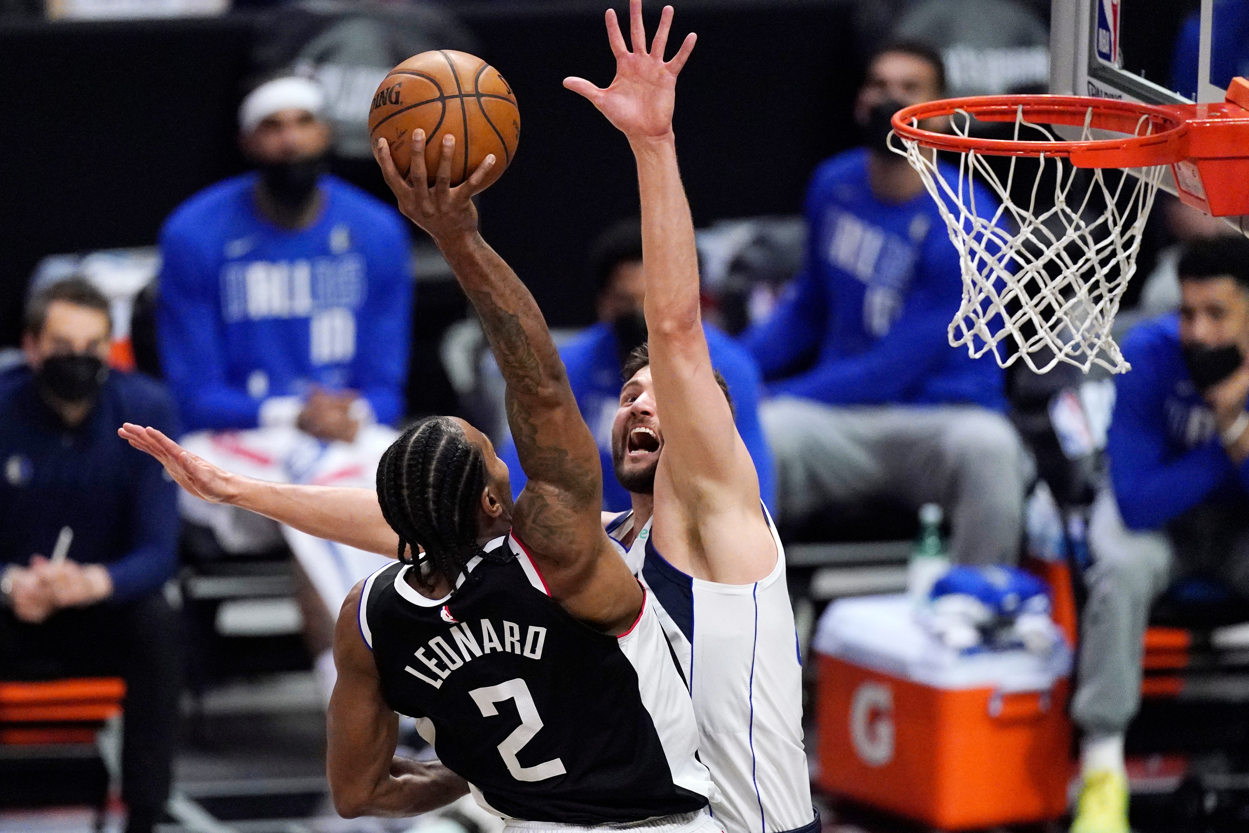Los Angeles Clippers forward Kawhi Leonardd, left, dunks over Dallas Mavericks forward Maxi Kleber during the second half in Game 1 of an NBA basketball first-round playoff series Saturday, May 22, 2021, in Los Angeles. (AP Photo/Mark J. Terrill)