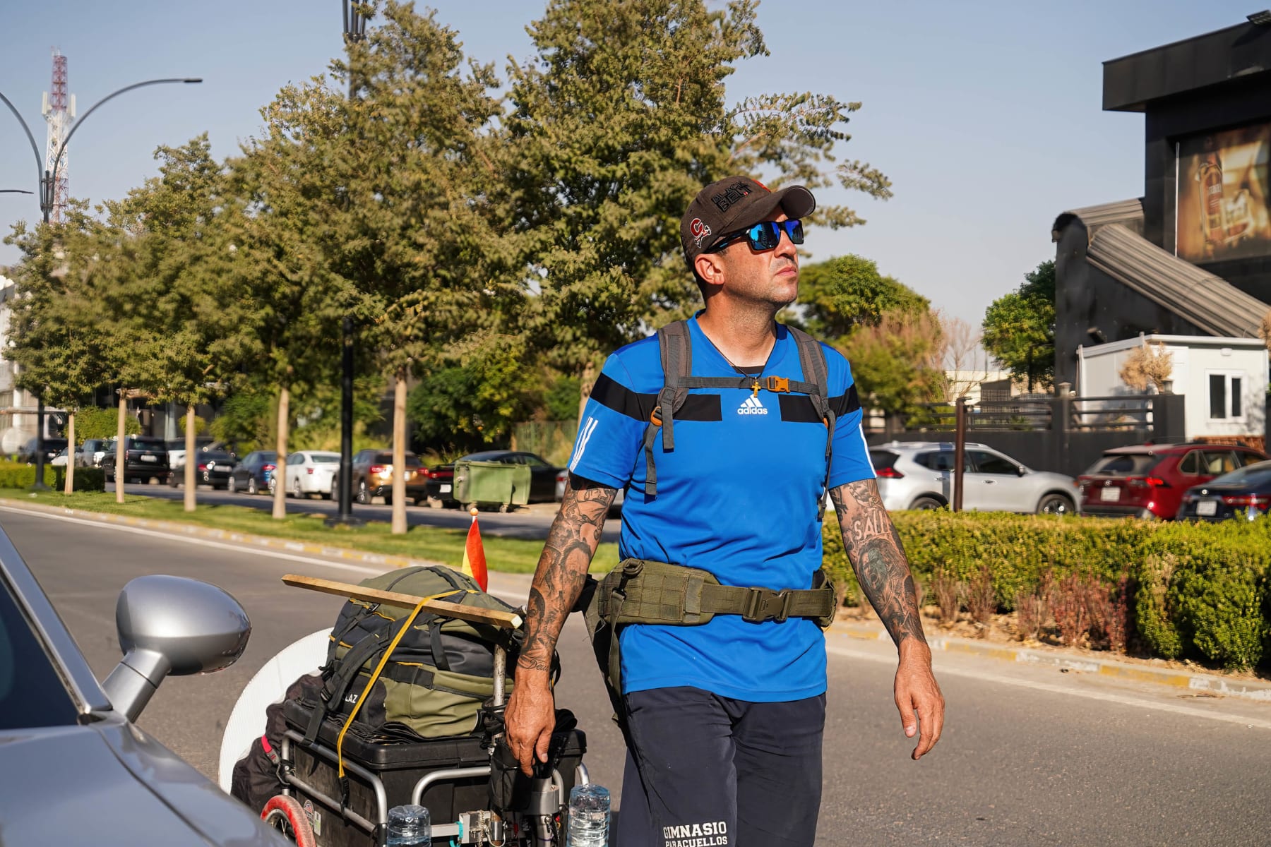 ERBIL, IRAQ - 2022/09/18: Santiago Sanchez walks in the city of Erbil in the Kurdistan region of Iraq during his journey to reach the Qatar 2022 World Cup on foot. Spaniard Santiago Sanchez 42 years old, set off by walking from the Spanish capital Madrid in January, he crossed most of Europe and Turkey (10 countries) with a distance of 5-6 thousand kilometers on foot. After 9 months of walking, he reached Iraq and will then go to Iran and Qatar via the Persian Gulf. He decided to take this adventure to prove to people that nothing is impossible and to support his country that is participating in the World Cup. When he walks he collects plastic waste, and on many occasions he changes it to get a plate of food, he has a tent where he sleeps and there are times when families give him a place in their homes to live with them for a few days to rest. (Photo by Ismael Adnan/SOPA Images/LightRocket via Getty Images)