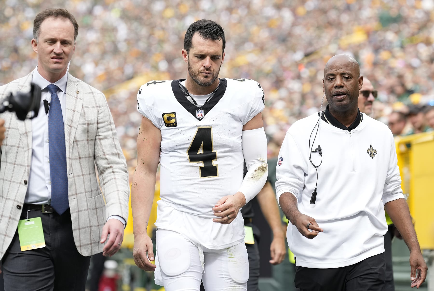 GREEN BAY, WISCONSIN - SEPTEMBER 24: New Orleans Saints staff walk off with Derek Carr #4 of the New Orleans Saints to the locker room during the third quarter against the Green Bay Packers at Lambeau Field on September 24, 2023 in Green Bay, Wisconsin. (Photo by Patrick McDermott/Getty Images)