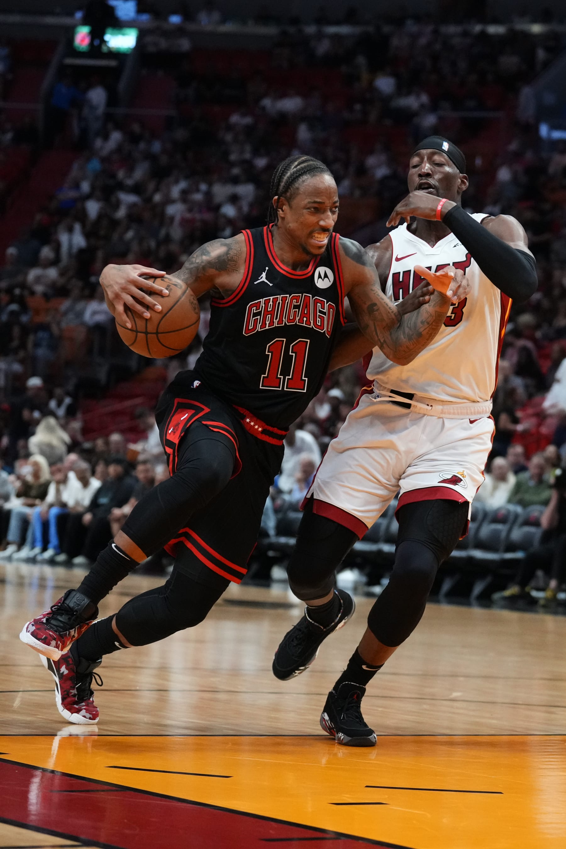 MIAMI, FLORIDA - APRIL 19: DeMar DeRozan #11 of the Chicago Bulls dribbles the ball against Bam Adebayo #13 of the Miami Heat in the third quarter during the Play-In Tournament at Kaseya Center on April 19, 2024 in Miami, Florida. NOTE TO USER: User expressly acknowledges and agrees that, by downloading and or using this photograph, User is consenting to the terms and conditions of the Getty Images License Agreement. (Photo by Rich Storry/Getty Images)