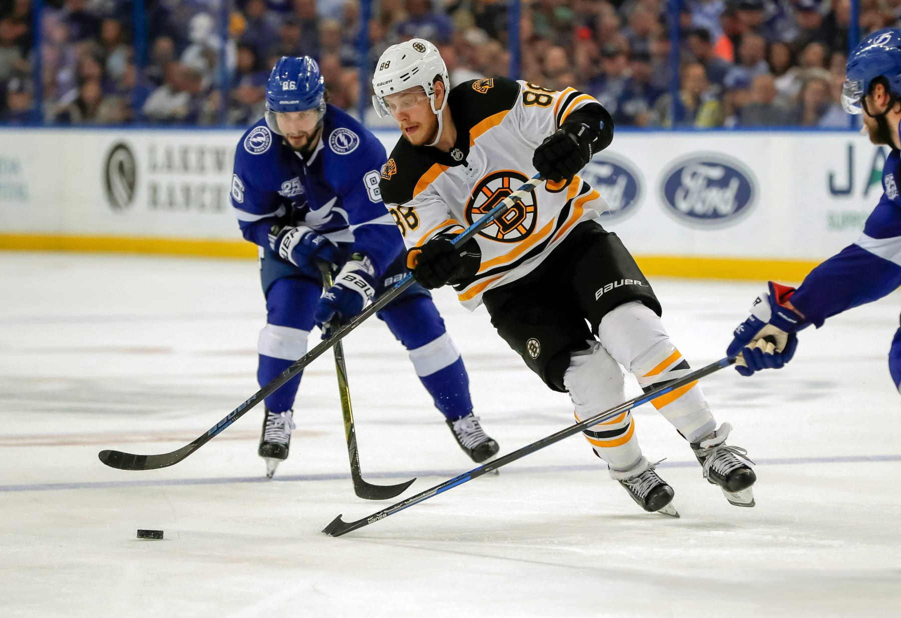 TAMPA, FL - APRIL  3: David Pastrnak #88 of the Boston Bruins avoids the check of Nikita Kucherov #86 of the Tampa Bay Lightning during the third period of the game at the Amalie Arena on April 3, 2018 in Tampa, Florida. (Photo by Mike Carlson/Getty Images) *** Local Caption *** Nikita Kucherov;David Pastrnak