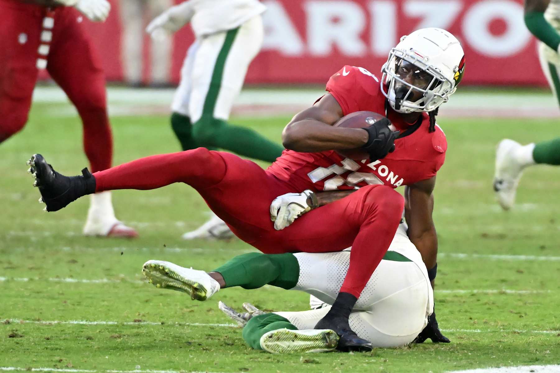 GLENDALE, ARIZONA - NOVEMBER 10: Marvin Harrison Jr. #18 of the Arizona Cardinals runs with the ball while being tackled by D.J. Reed #4 of the New York Jets in the fourth quarter at State Farm Stadium on November 10, 2024 in Glendale, Arizona. (Photo by Norm Hall/Getty Images)