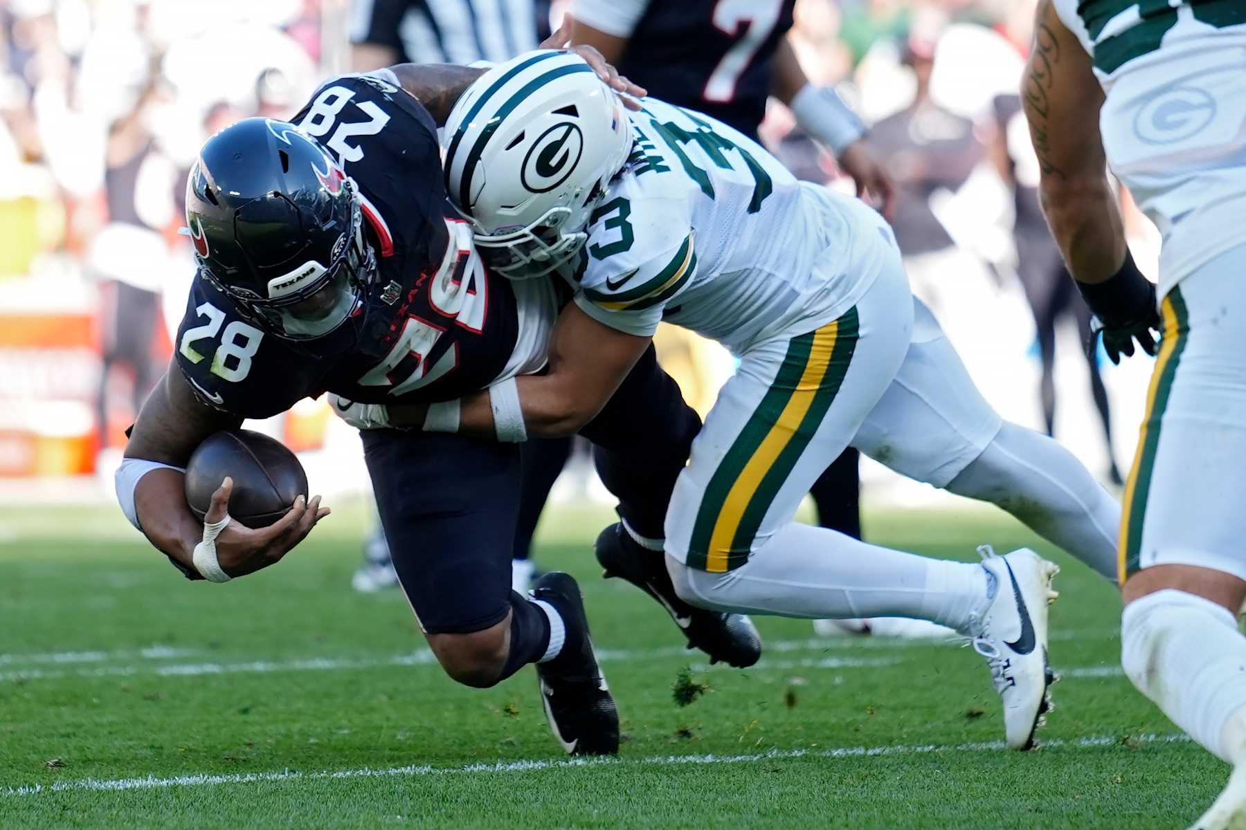 GREEN BAY, WISCONSIN - OCTOBER 20: Evan Williams #33 of the Green Bay Packers tackles Joe Mixon #28 of the Houston Texans on an unsuccessful two point conversion during the second quarter at Lambeau Field on October 20, 2024 in Green Bay, Wisconsin. (Photo by Patrick McDermott/Getty Images)