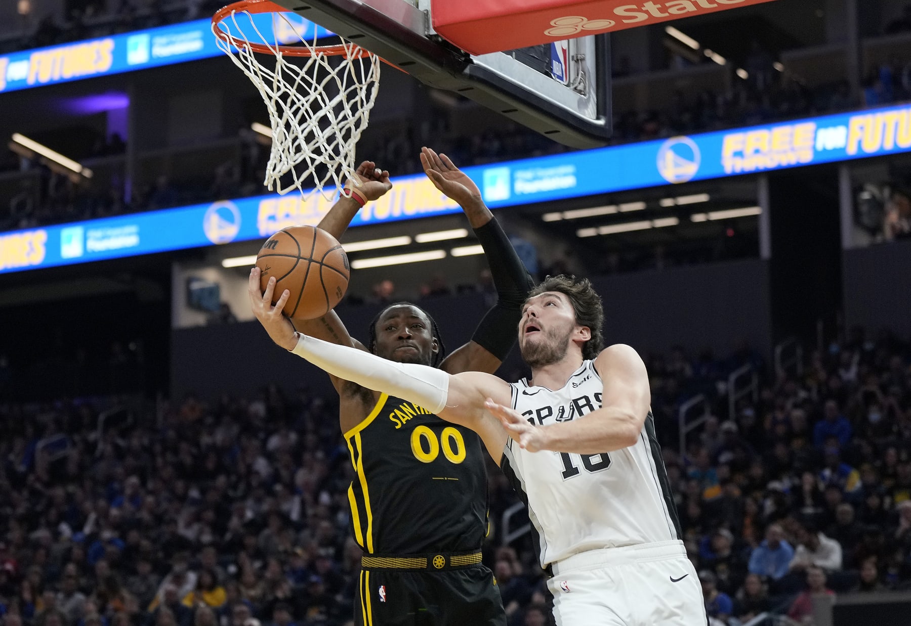 SAN FRANCISCO, CALIFORNIA - NOVEMBER 24: Cedi Osman #16 of the San Antonio Spurs drives to the basket against Jonathan Kuminga #00 of the Golden State Warriors during the first quarter of the NBA In-Season Tournament game at Chase Center on November 24, 2023 in San Francisco, California. NOTE TO USER: User expressly acknowledges and agrees that, by downloading and or using this photograph, User is consenting to the terms and conditions of the Getty Images License Agreement. (Photo by Thearon W. Henderson/Getty Images)