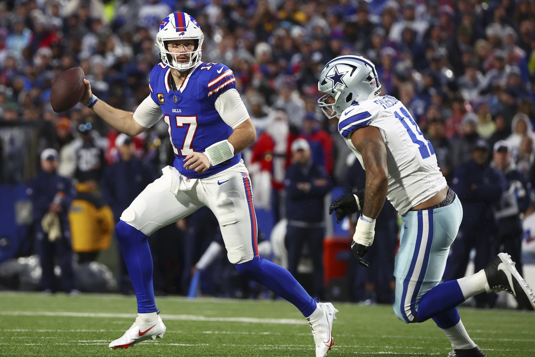 Buffalo Bills quarterback Josh Allen (17) looks to pass against Dallas Cowboys linebacker Micah Parsons (11) during the first quarter of an NFL football game, Sunday, Dec. 17, 2023, in Orchard Park, N.Y. (AP Photo/Jeffrey T. Barnes)