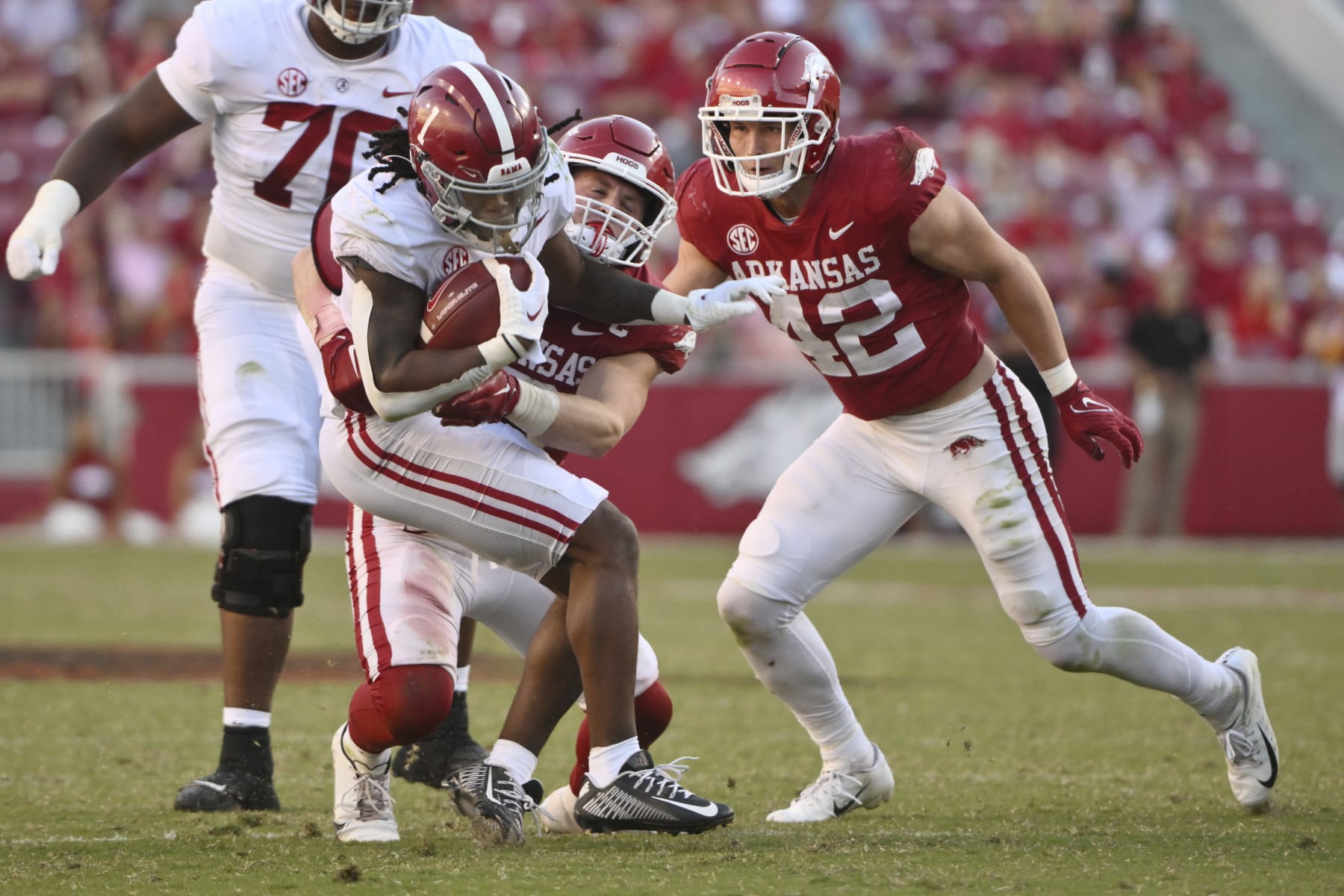 Arkansas defenders Bumper Pool (10) and Drew Sanders (42) stop Alabama running back Jahmyr Gibbs (1) during an NCAA college football game Saturday, Oct. 1, 2022, in Fayetteville, Ark. (AP Photo/Michael Woods)