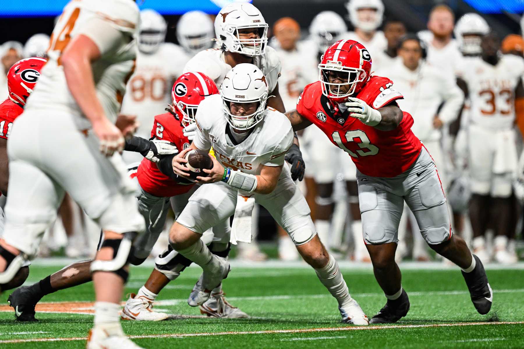 ATLANTA, GA  DECEMBER 07:  Texas quarterback Quinn Ewers (3) is pressured by Georgia defenders Smael Mondon Jr. (2) and Mykel Williams (13) during the SEC Championship game between the Texas Longhorns and the Georgia Bulldogs on December 7th, 2024 at Mercedes-Benz Stadium in Atlanta, GA.  (Photo by Rich von Biberstein/Icon Sportswire via Getty Images)