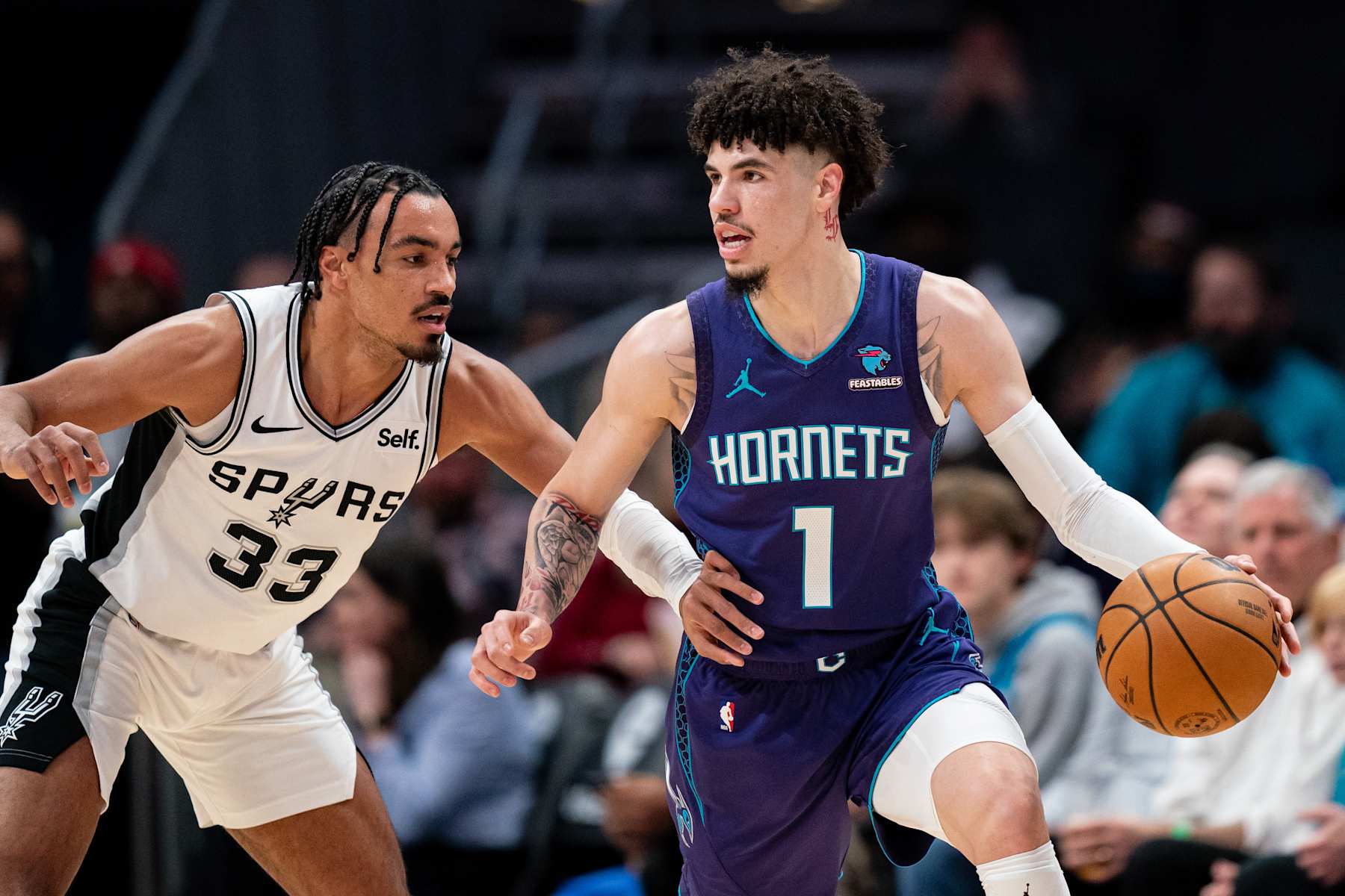 CHARLOTTE, NORTH CAROLINA - JANUARY 19: Tre Jones #33 of the San Antonio Spurs guards LaMelo Ball #1 of the Charlotte Hornets in the first quarter during their game at Spectrum Center on January 19, 2024 in Charlotte, North Carolina. NOTE TO USER: User expressly acknowledges and agrees that, by downloading and or using this photograph, User is consenting to the terms and conditions of the Getty Images License Agreement. (Photo by Jacob Kupferman/Getty Images)