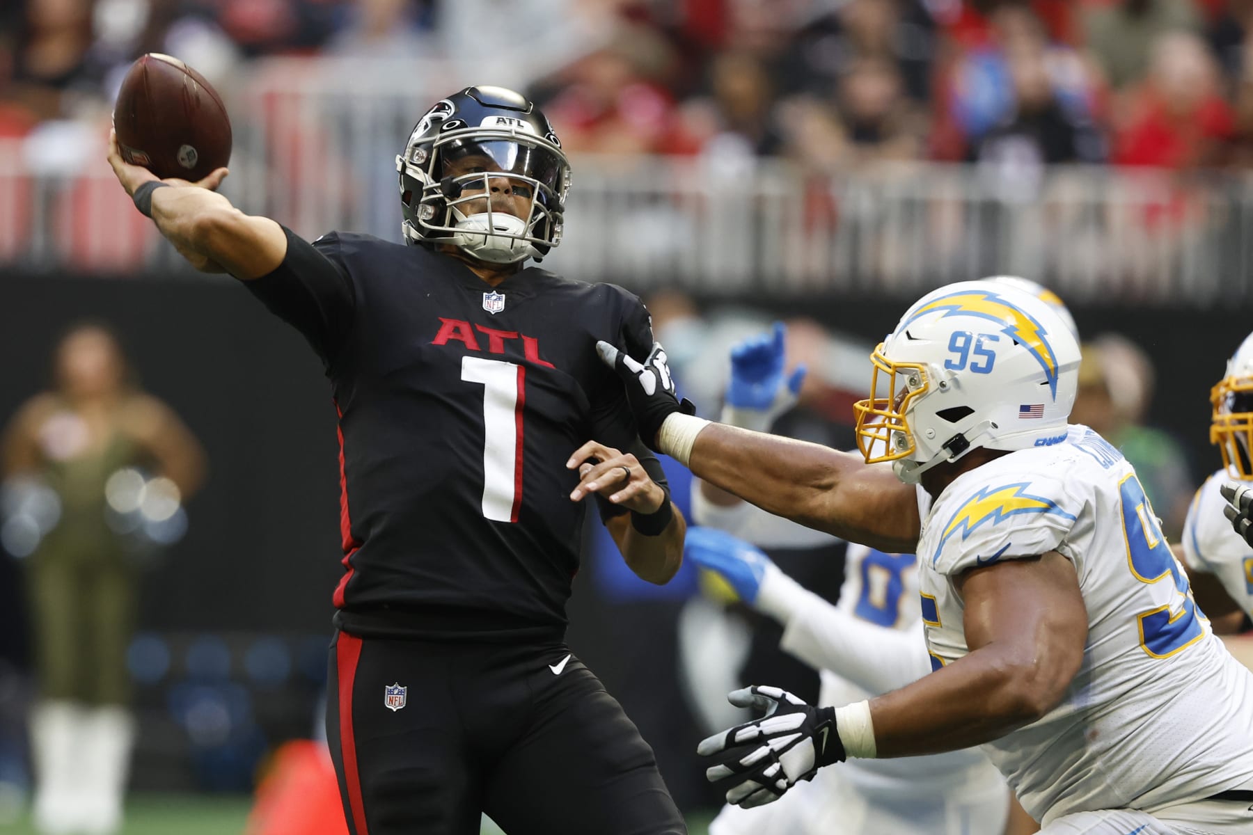 CORRECTS DATE TO SUNDAY, NOV. 6 INSTEAD OF TUESDAY, DEC. 6 - Atlanta Falcons quarterback Marcus Mariota (1) passes over Los Angeles Chargers defensive tackle Christian Covington (95) during the second half of an NFL football game, Sunday, Nov. 6, 2022, in Atlanta. (AP Photo/Butch Dill)