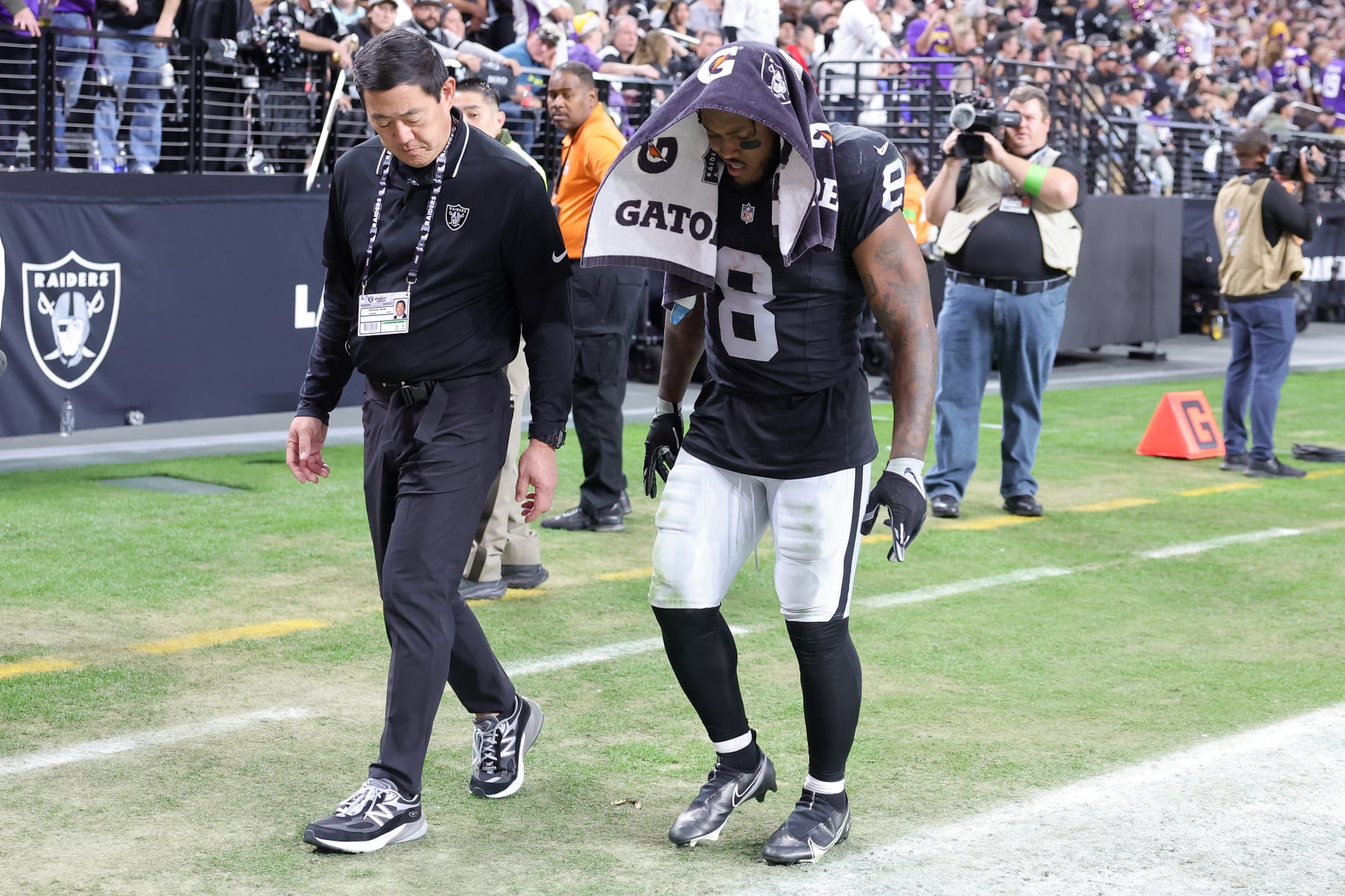 LAS VEGAS, NEVADA - DECEMBER 10: Dr. Michael Miao  walks with Josh Jacobs #8 of the Las Vegas Raiders as he leaves the field after an injury during the second half of a game against the Minnesota Vikings at Allegiant Stadium on December 10, 2023 in Las Vegas, Nevada. (Photo by Ethan Miller/Getty Images)