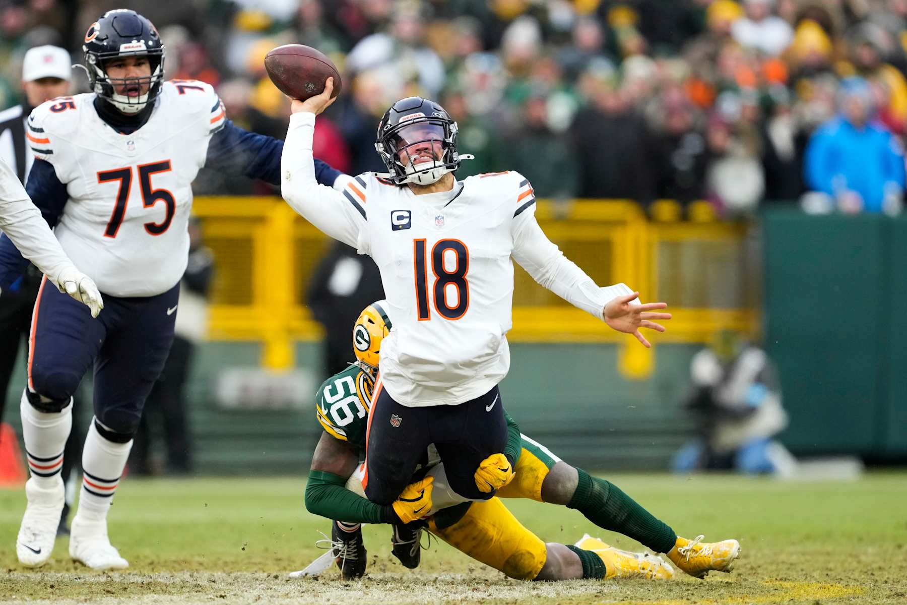 GREEN BAY, WISCONSIN - JANUARY 05: Caleb Williams #18 of the Chicago Bears throws a pass while being tackled by Edgerrin Cooper #56 of the Green Bay Packers in the fourth quarter at Lambeau Field on January 05, 2025 in Green Bay, Wisconsin. (Photo by Patrick McDermott/Getty Images)