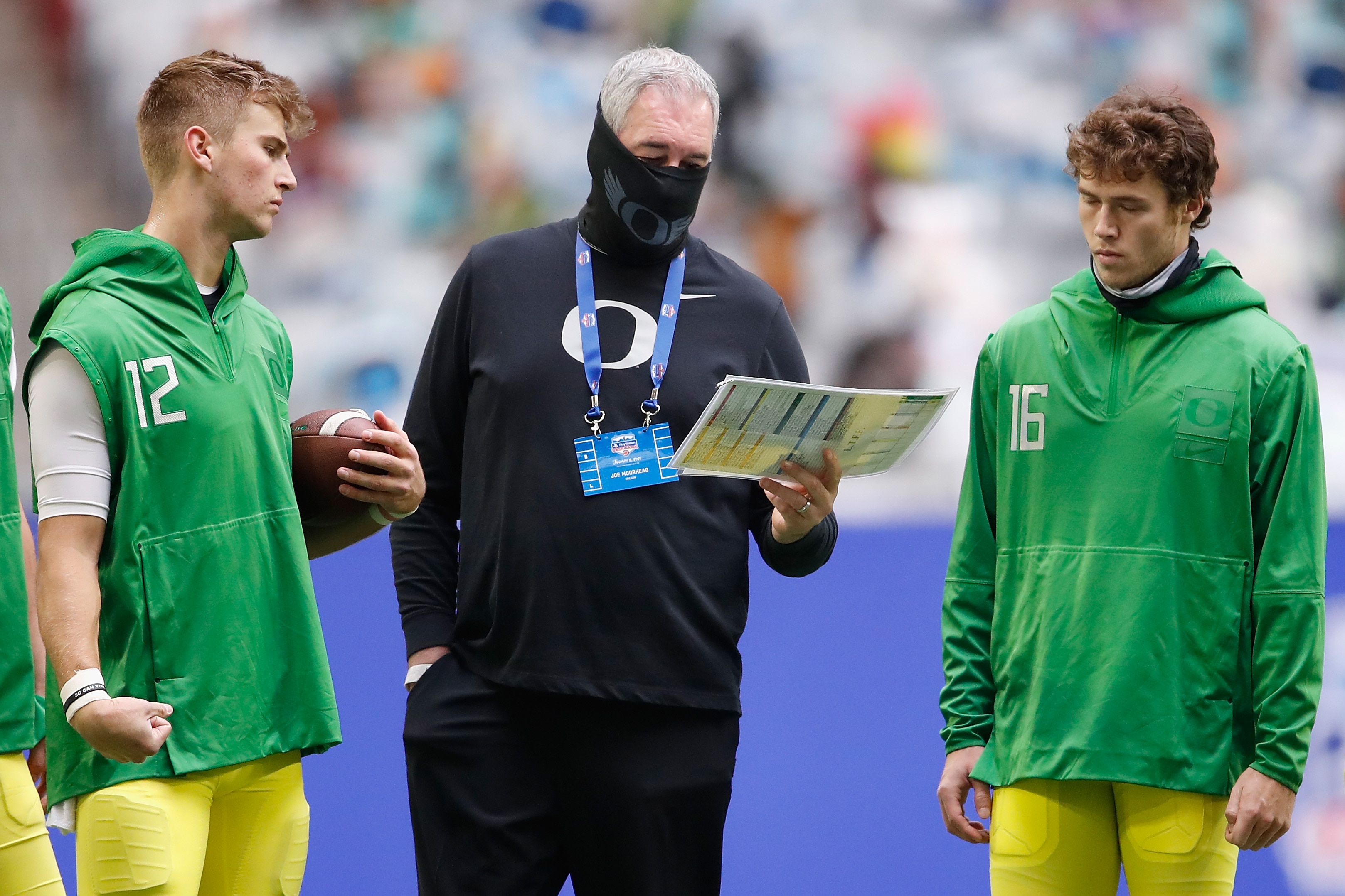 GLENDALE, ARIZONA - JANUARY 02: Offensive coordinator Joe Moorhead of the Oregon Ducks talks with quarterbacks Tyler Shough #12 and Bradley Yaffe #16 before the PlayStation Fiesta Bowl against the Iowa State Cyclones at State Farm Stadium on January 02, 2021 in Glendale, Arizona. (Photo by Christian Petersen/Getty Images)