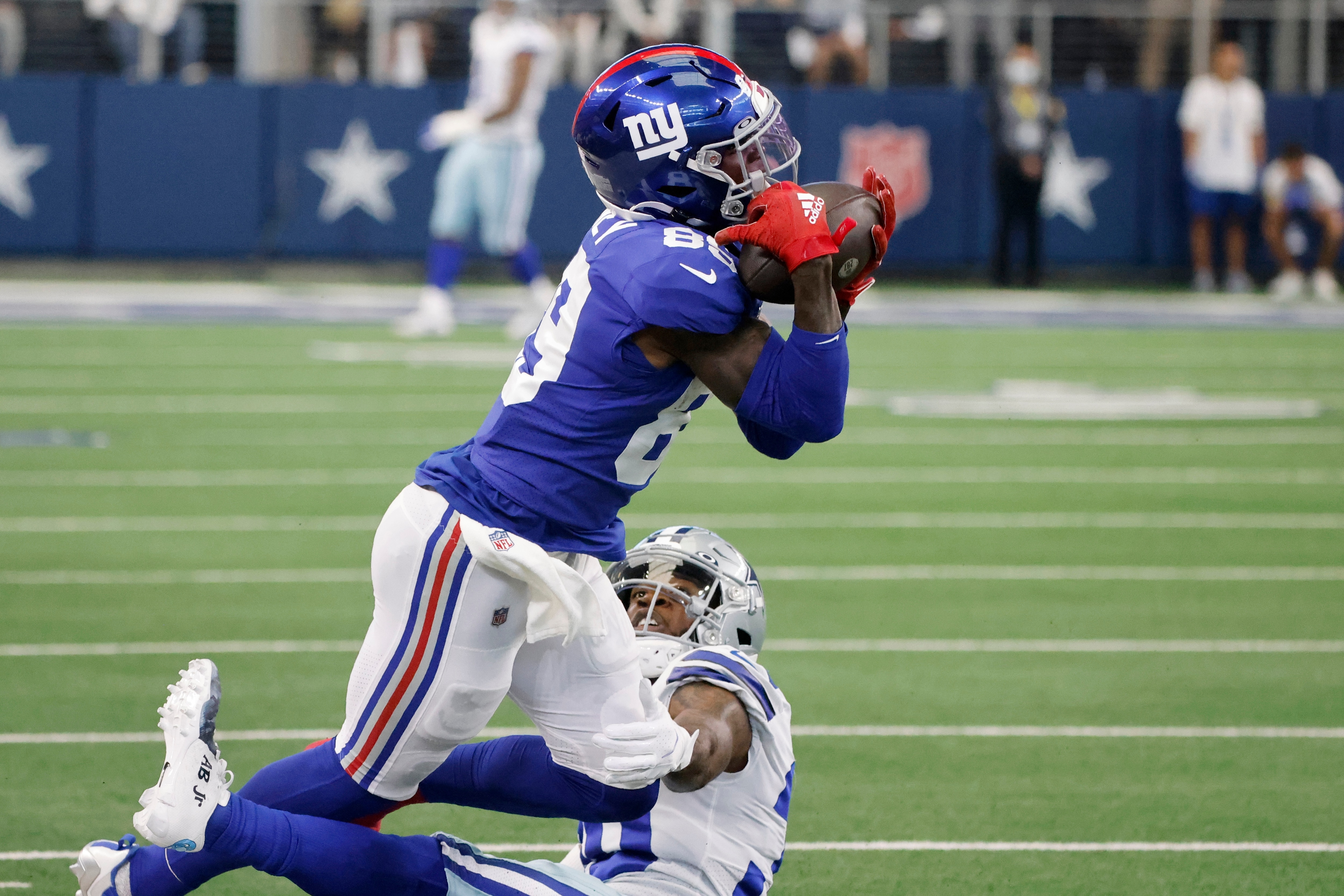 New York Giants wide receiver Kadarius Toney (89) catches a pass as Dallas Cowboys cornerback Anthony Brown, bottom, defends in the first half of an NFL football game in Arlington, Texas, Sunday, Oct. 10, 2021. (AP Photo/Michael Ainsworth)