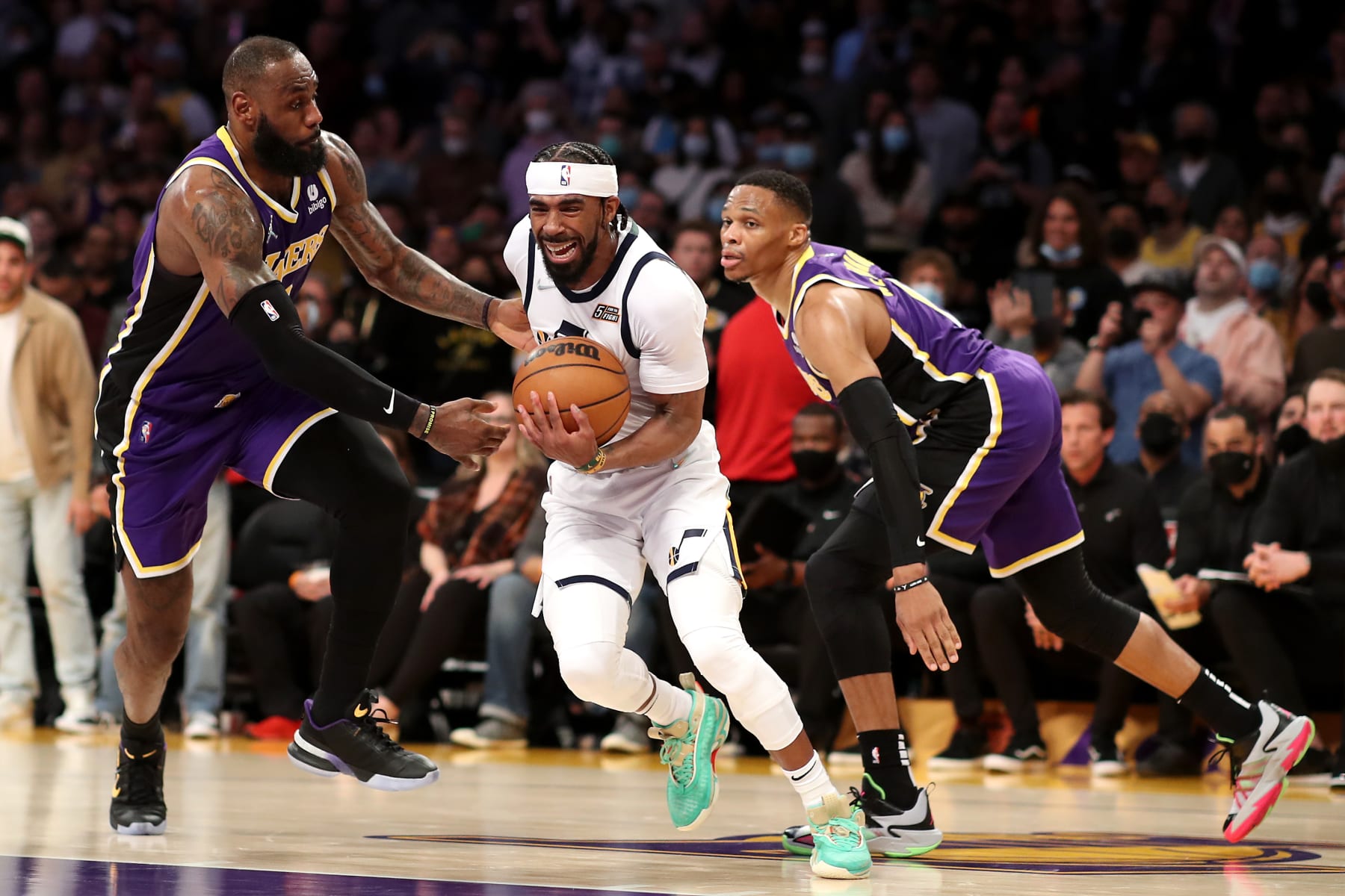 LOS ANGELES, CALIFORNIA - FEBRUARY 16: Mike Conley #11 of the Utah Jazz drives to the basket against LeBron James #6 and Russell Westbrook #0 of the Los Angeles Lakers during the fourth quarter at Crypto.com Arena on February 16, 2022 in Los Angeles, California. NOTE TO USER: User expressly acknowledges and agrees that, by downloading and or using this Photograph, user is consenting to the terms and conditions of the Getty Images License Agreement. (Photo by Katelyn Mulcahy/Getty Images)