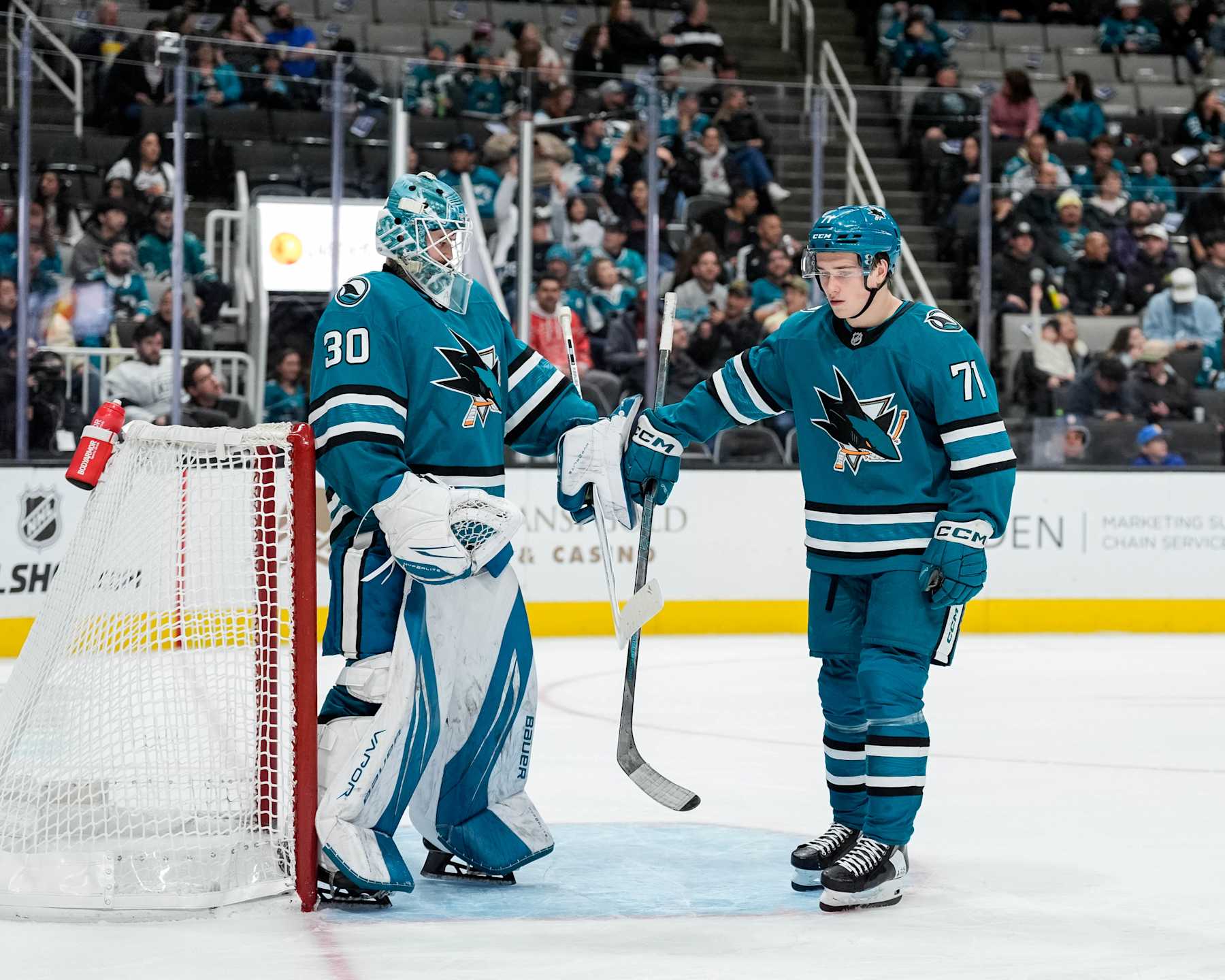 SAN JOSE, CALIFORNIA - NOVEMBER 25: Macklin Celebrini #71 of the San Jose Sharks high-fives goaltender Yaroslav Askarov #30 against the Los Angeles Kings at SAP Center on November 25, 2024 in San Jose, California. (Photo by Andreea Cardani/NHLI via Getty Images)
