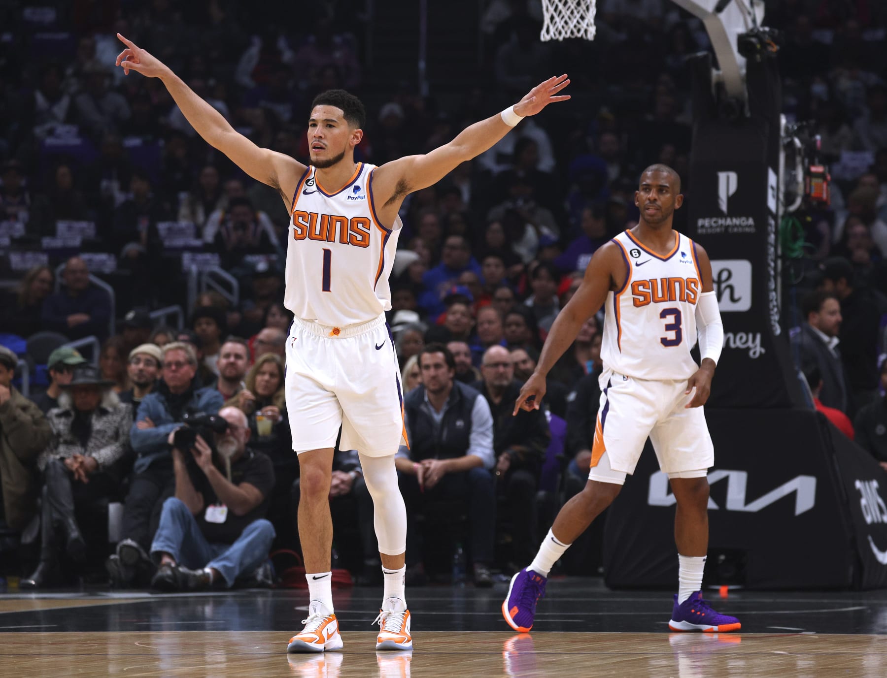 LOS ANGELES, CALIFORNIA - DECEMBER 15: Devin Booker #1 and Chris Paul #3 of the Phoenix Suns direct the defense during the first half against the LA Clippers at Crypto.com Arena on December 15, 2022 in Los Angeles, California. (Photo by Harry How/Getty Images) NOTE TO USER: User expressly acknowledges and agrees that, by downloading and/or using this photograph, User is consenting to the terms and conditions of the Getty Images License Agreement. Mandatory Copyright Notice: Copyright 2022 NBAE.