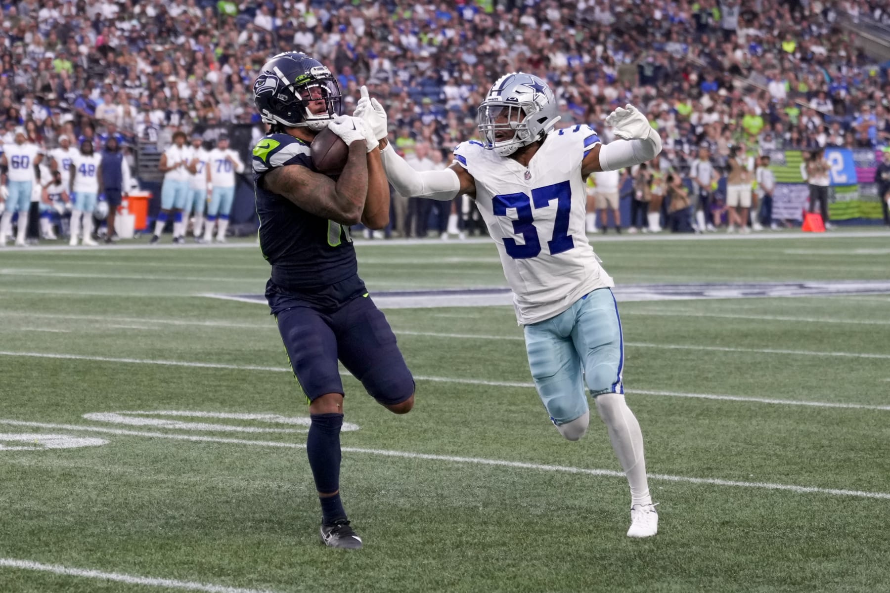 Seattle Seahawks wide receiver Jaxon Smith-Njigba catches a pass in front of Dallas Cowboys cornerback Eric Scott Jr. during the first half of a preseason NFL football game Saturday, Aug. 19, 2023, in Seattle. (AP Photo/Stephen Brashear)