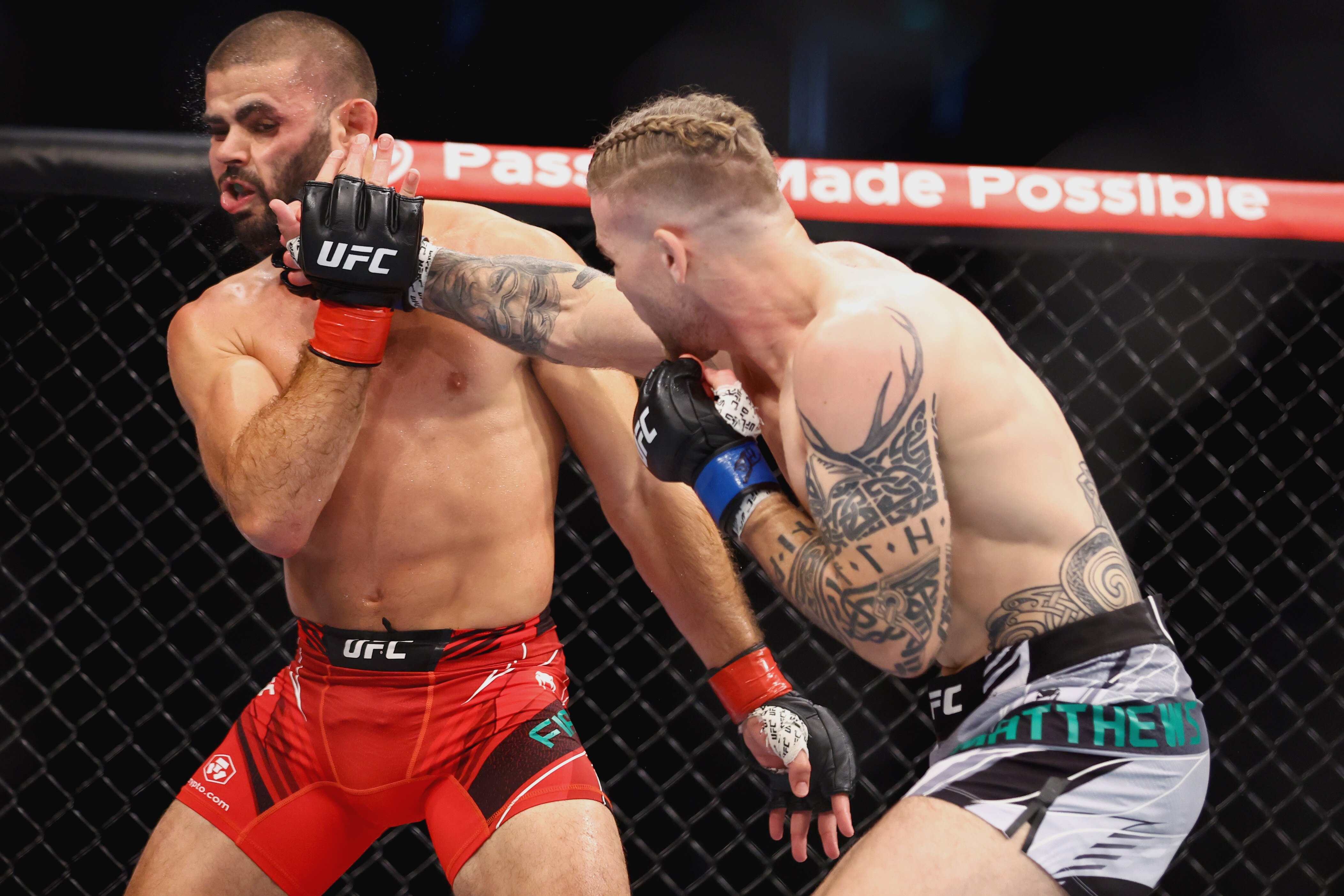 SINGAPORE, SINGAPORE - JUNE 12: Andre Fialho of Portugal 
 exchanges strikes with Jake Matthews of Australia during their Welterweight Fight at Singapore Indoor Stadium on June 12, 2022 in Singapore. (Photo by Yong Teck Lim/Getty Images)