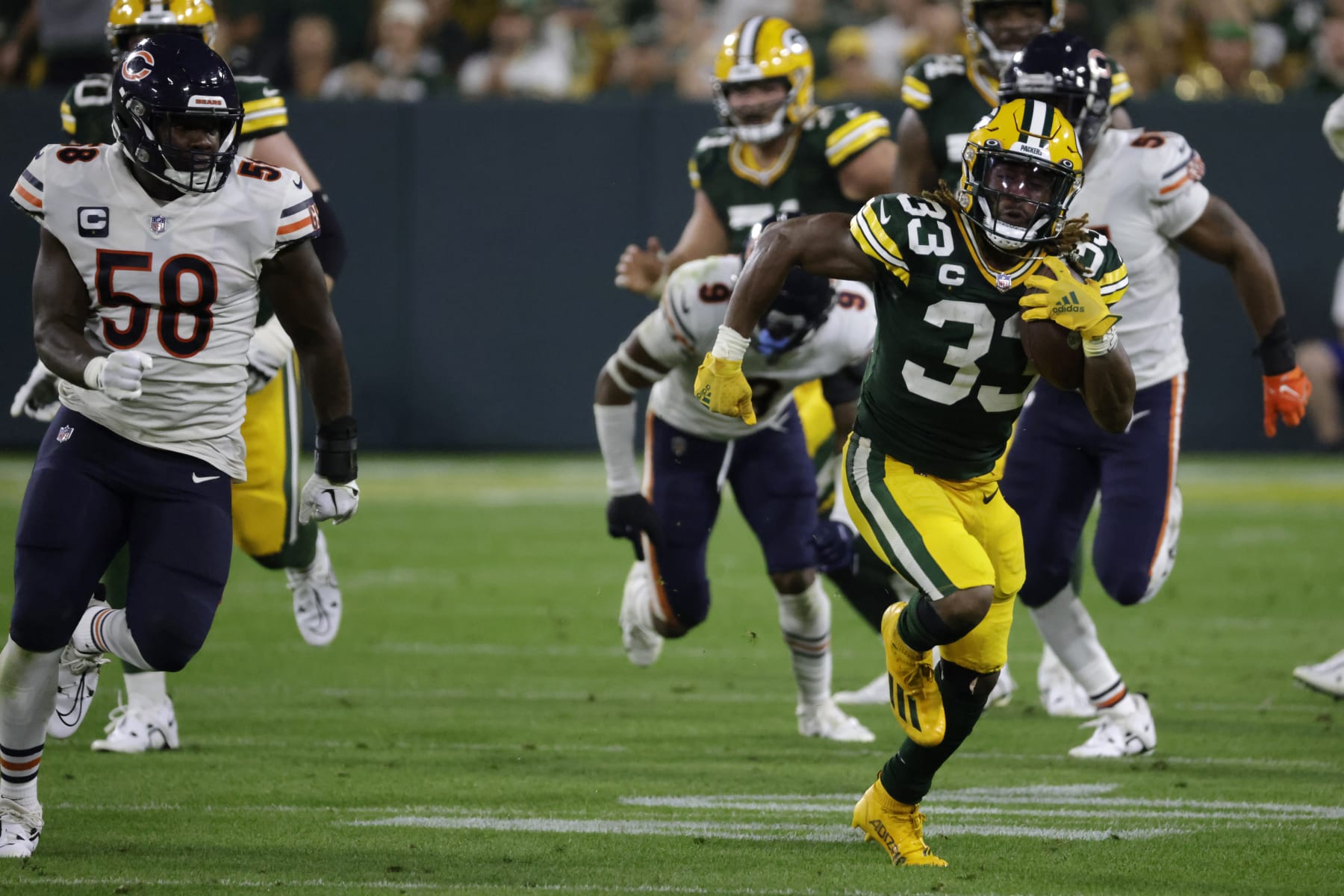 Green Bay Packers running back Aaron Jones (33) runs from Chicago Bears linebacker Roquan Smith (58) during the second half of an NFL football game Sunday, Sept. 18, 2022, in Green Bay, Wis. (AP Photo/Mike Roemer)