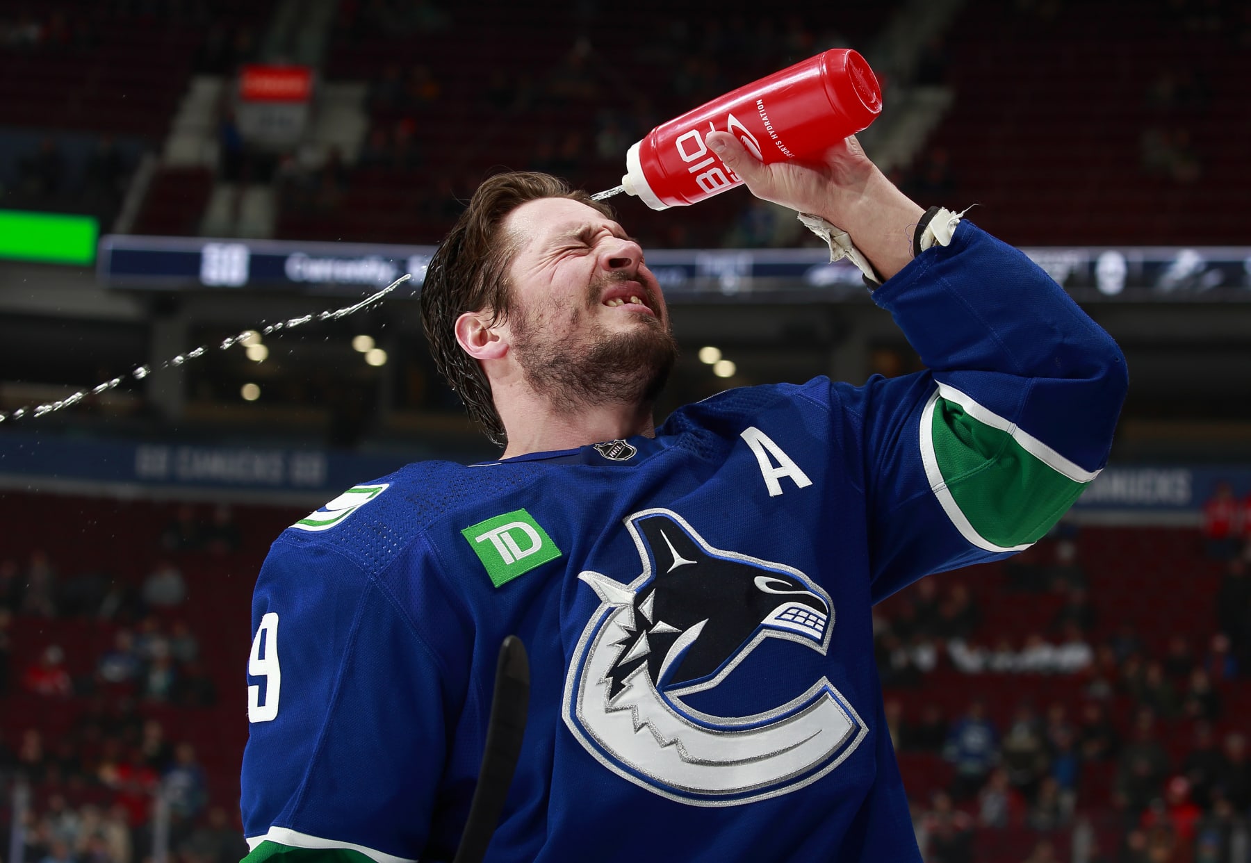 VANCOUVER, CANADA - NOVEMBER 29: J.T. Miller #9 of the Vancouver Canucks sprays himself with water during warm-up before their NHL game against the Washington Capitals at Rogers Arena November 29, 2022 in Vancouver, British Columbia, Canada.  (Photo by Jeff Vinnick/NHLI via Getty Images)