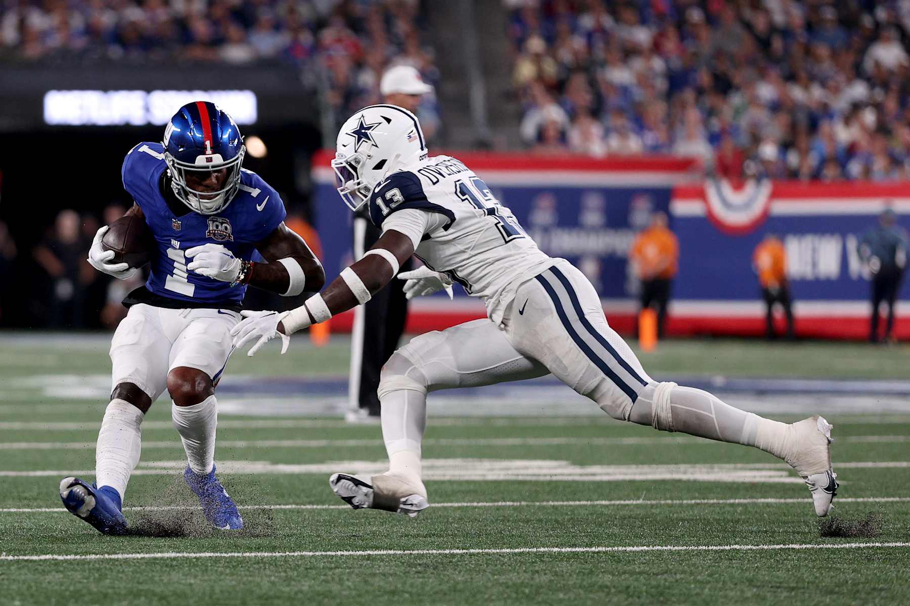 EAST RUTHERFORD, NEW JERSEY - SEPTEMBER 26: Malik Nabers #1 of the New York Giants carries the ball while DeMarvion Overshown #13 of the Dallas Cowboys attempts a tackle during the second quarter at MetLife Stadium on September 26, 2024 in East Rutherford, New Jersey. (Photo by Sarah Stier/Getty Images)
