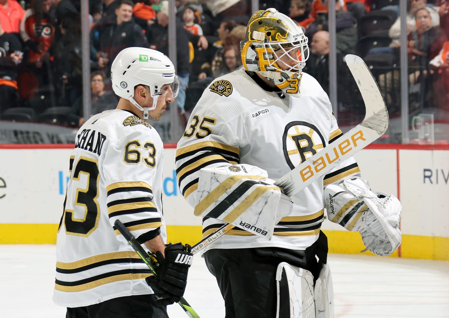 PHILADELPHIA, PENNSYLVANIA - JANUARY 27:  Brad Marchand #63 and Linus Ullmark #35 of the Boston Bruins skate toward the bench at the end of the first period against the Philadelphia Flyers at the Wells Fargo Center on January 27, 2024 in Philadelphia, Pennsylvania.  (Photo by Len Redkoles/NHLI via Getty Images)