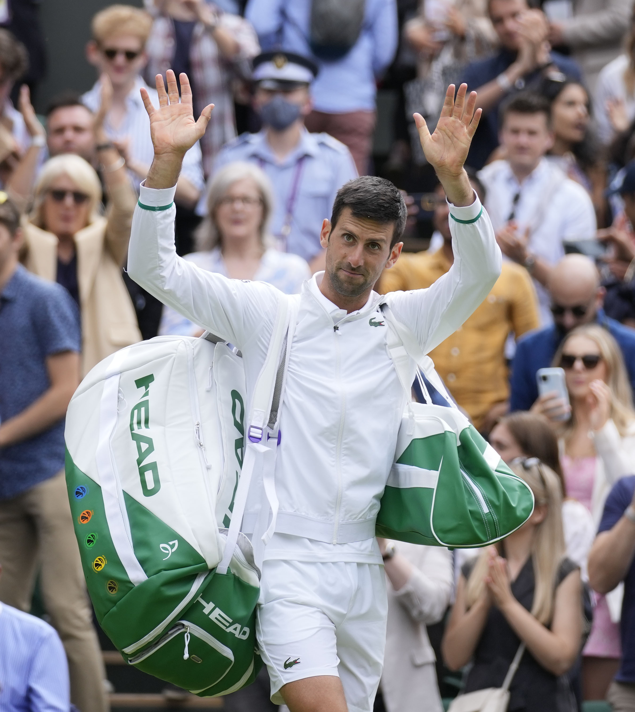 Serbia's Novak Djokovic leaves the court after defeating Hungary's Marton Fucsovics during the men's singles quarterfinals match on day nine of the Wimbledon Tennis Championships in London, Wednesday, July 7, 2021.(AP Photo/Kirsty Wigglesworth)