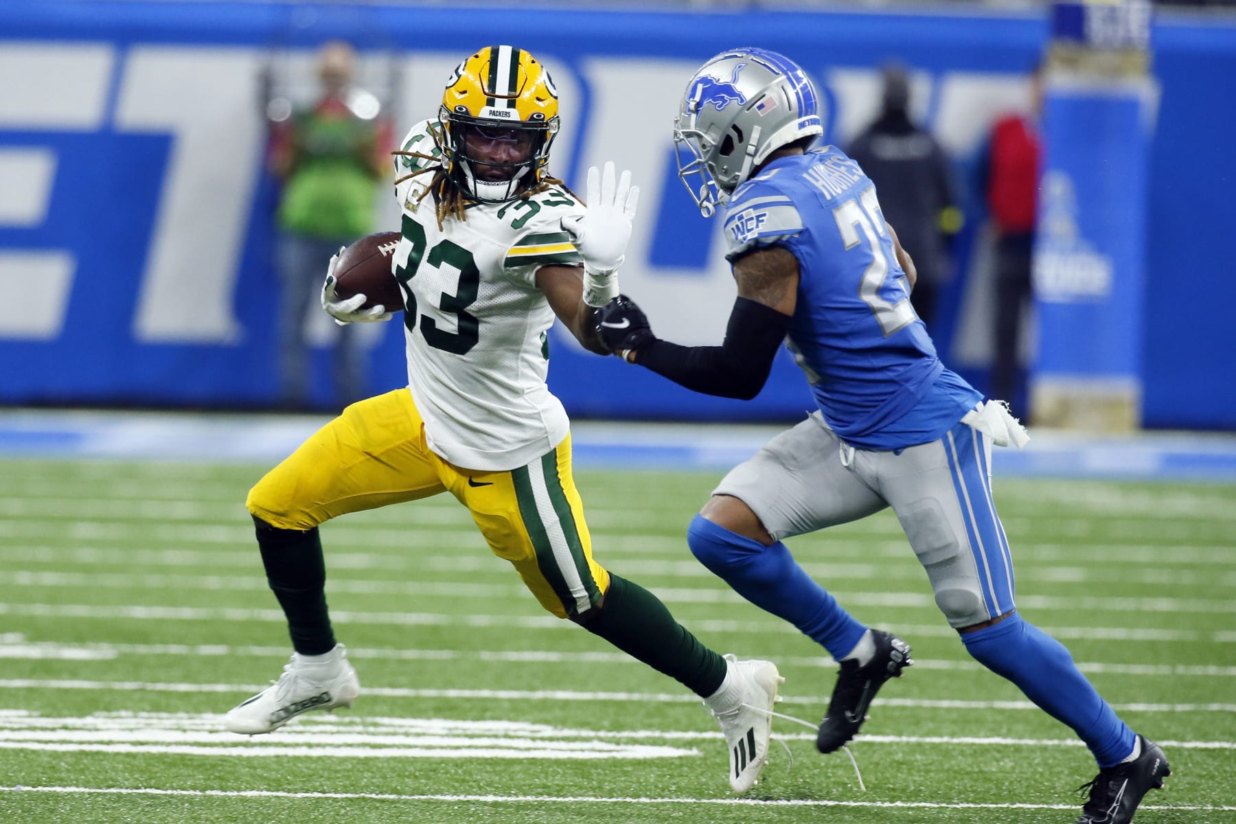 Green Bay Packers running back Aaron Jones (33) is chased by Detroit Lions cornerback Mike Hughes (23) during the second half of an NFL football game, Sunday, Nov. 6, 2022, in Detroit. (AP Photo/Duane Burleson)