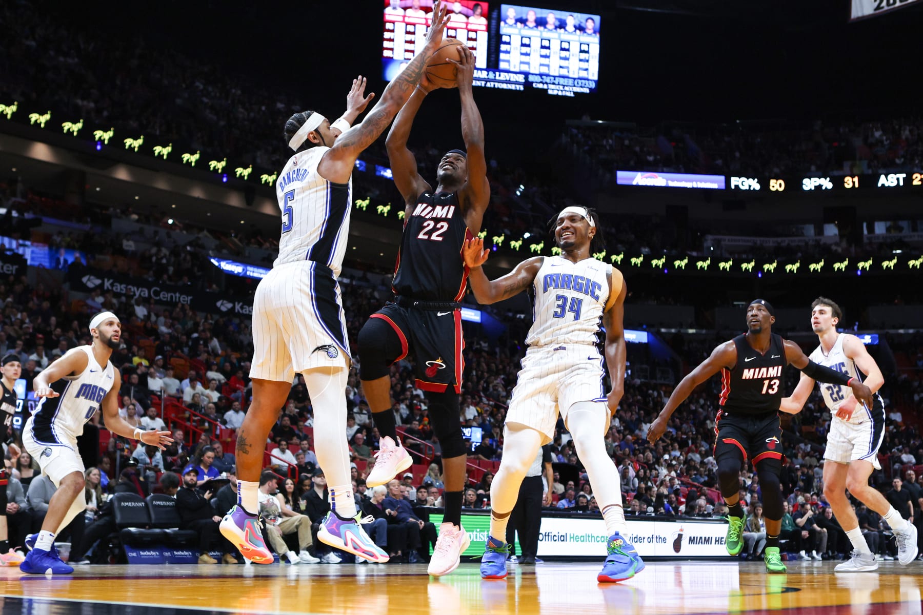 MIAMI, FLORIDA - FEBRUARY 06: Jimmy Butler #22 of the Miami Heat drives against Paolo Banchero #5 of the Orlando Magic during the third quarter at Kaseya Center on February 06, 2024 in Miami, Florida. NOTE TO USER: User expressly acknowledges and agrees that, by downloading and or using this photograph, User is consenting to the terms and conditions of the Getty Images License Agreement. (Photo by Megan Briggs/Getty Images)