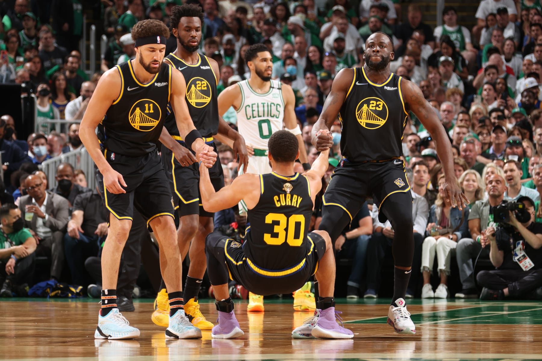 BOSTON, MA - JUNE 10: Klay Thompson #11 and Draymond Green #23 of the Golden State Warriors help up Stephen Curry #30 of the Golden State Warriors during Game Four of the 2022 NBA Finals on June 10, 2022 at TD Garden in Boston, Massachusetts. NOTE TO USER: User expressly acknowledges and agrees that, by downloading and or using this photograph, user is consenting to the terms and conditions of Getty Images License Agreement. Mandatory Copyright Notice: Copyright 2022 NBAE (Photo by Nathaniel S. Butler/NBAE via Getty Images)
