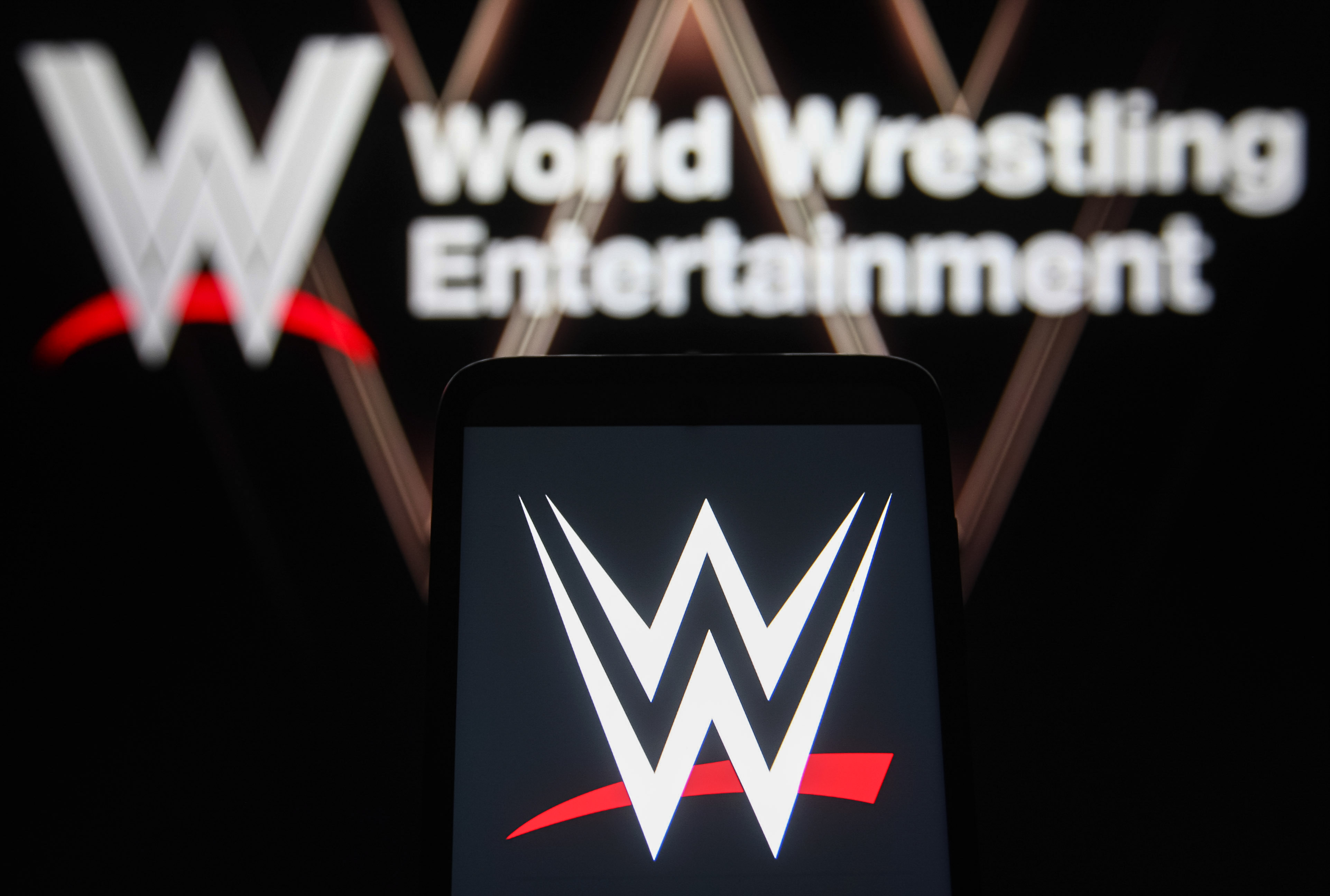 UKRAINE - 2021/08/25: In this photo illustration a World Wrestling Entertainment (WWE) logo is seen on a smartphone and a pc screen. (Photo Illustration by Pavlo Gonchar/SOPA Images/LightRocket via Getty Images)