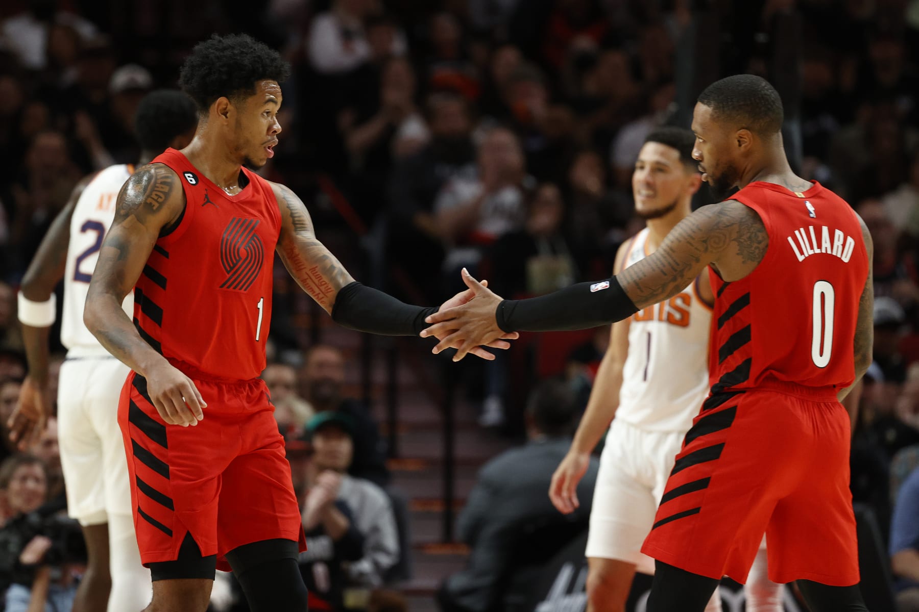 PORTLAND, OREGON - OCTOBER 21: Anfernee Simons #1 and Damian Lillard #0 of the Portland Trail Blazers high five against the Phoenix Suns during the second quarter at Moda Center on October 21, 2022 in Portland, Oregon. NOTE TO USER: User expressly acknowledges and agrees that, by downloading and or using this photograph, User is consenting to the terms and conditions of the Getty Images License Agreement. (Photo by Steph Chambers/Getty Images)