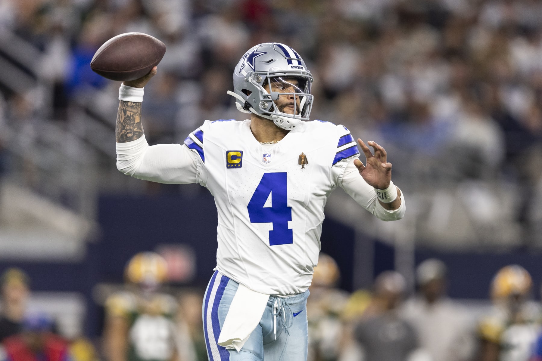 ARLINGTON, TEXAS - JANUARY 14: Dak Prescott #4 of the Dallas Cowboys looks to pass on the run during an NFL wild-card playoff football game between the Dallas Cowboys and the Green Bay Packers at AT&T Stadium on January 14, 2024 in Arlington, Texas. (Photo by Michael Owens/Getty Images)