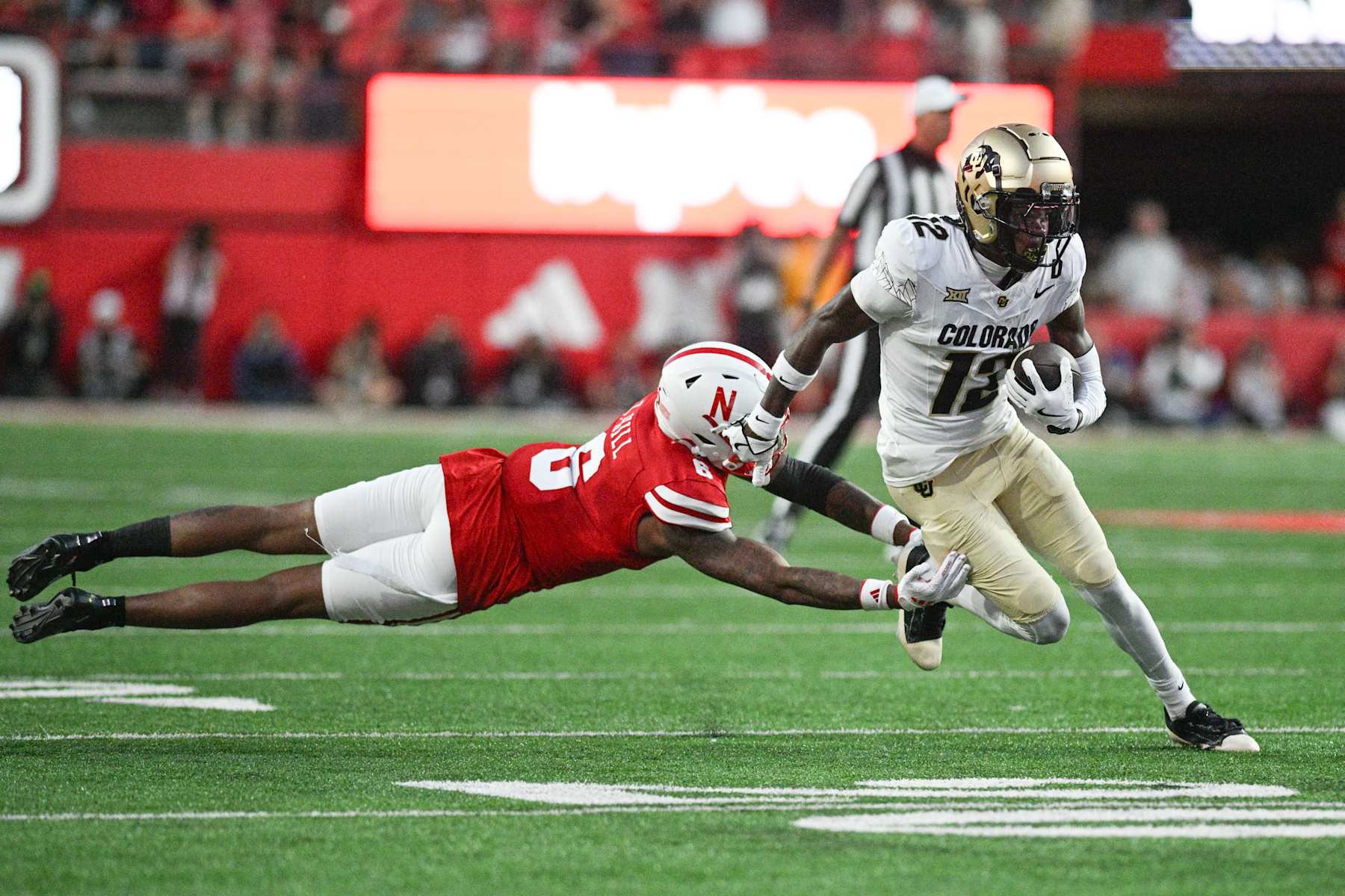 LINCOLN, NEBRASKA - SEPTEMBER 07: Travis Hunter #12 of the Colorado Buffaloes steps out of the tackle from Tommi Hill #6 of the Nebraska Cornhuskers during the second quarter at Memorial Stadium on September 7, 2024 in Lincoln, Nebraska. (Photo by Steven Branscombe/Getty Images)