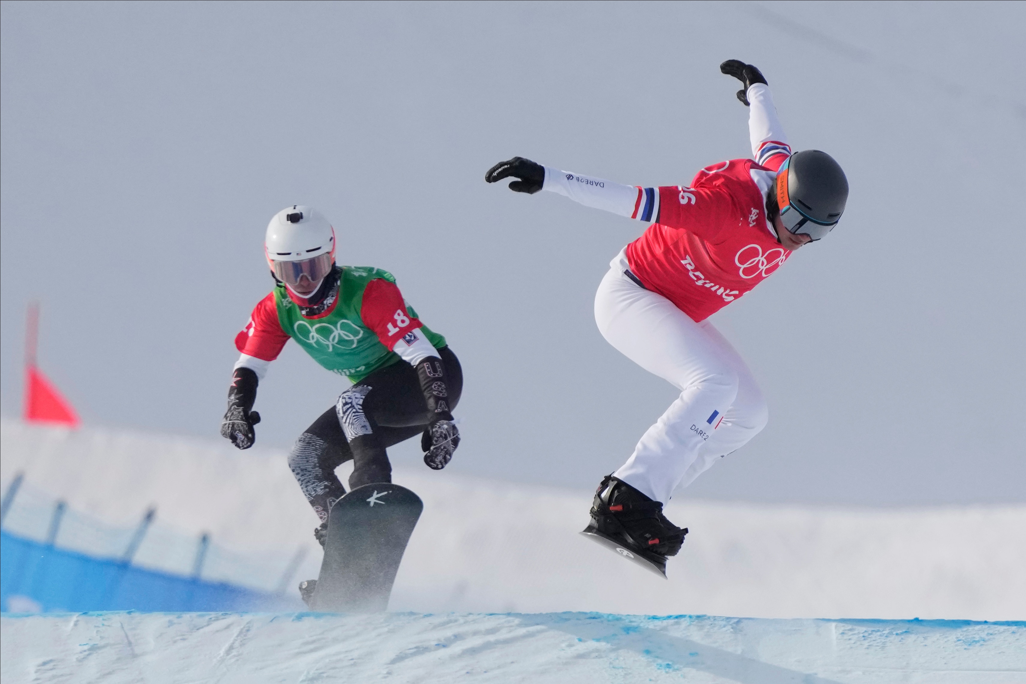 France's Merlin Surget (16) and United States' Jake Vedder (18) run the course during the men's cross finals at the 2022 Winter Olympics, Thursday, Feb. 10, 2022, in Zhangjiakou, China. (AP Photo/Lee Jin-man)